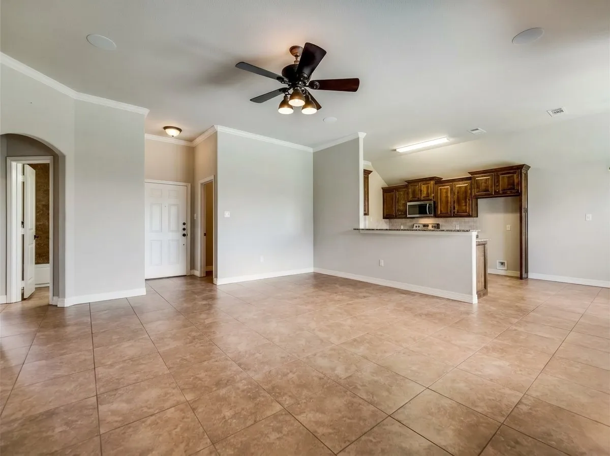 Open-concept living area with tile flooring and a ceiling fan