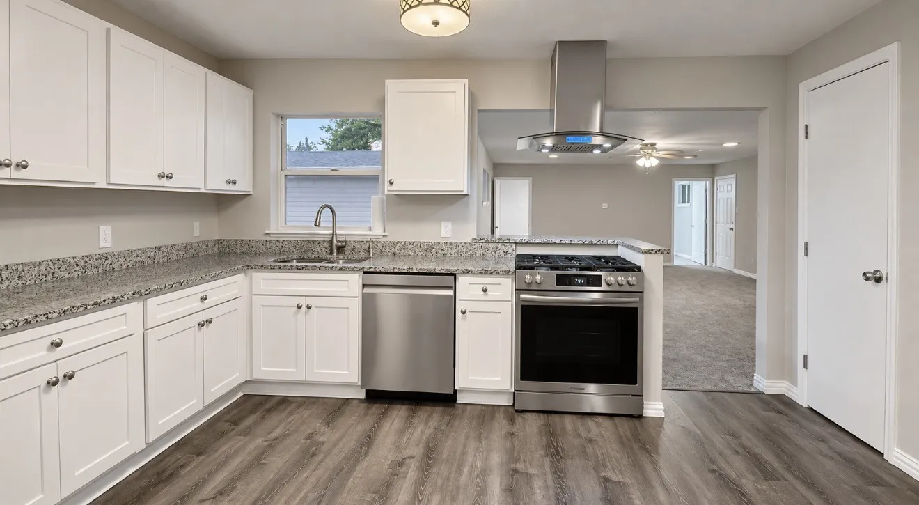 Kitchen featuring white cabinetry, granite-style countertops, stainless steel appliances, and wood-finish flooring. Virtually Staged