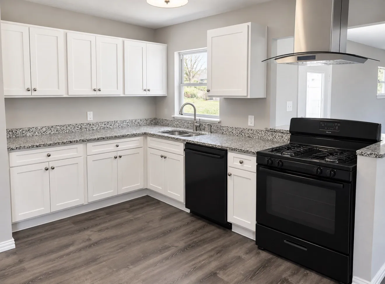 Kitchen featuring white cabinetry, speckled countertops, stainless steel sink, black appliances, and wood-finish flooring