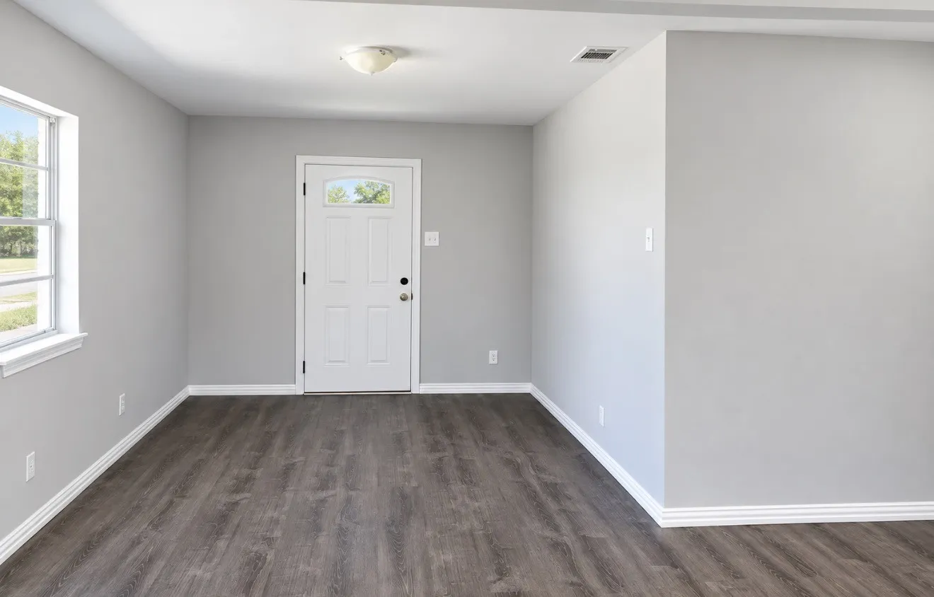 Entry area featuring wood-finish flooring, light gray walls, a white paneled door with an arched window, and a white framed window