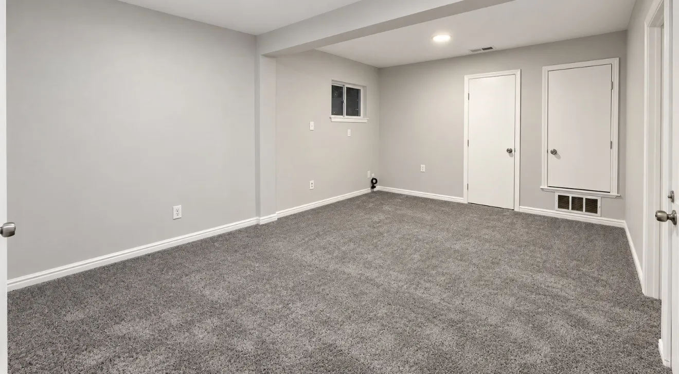 Gray wall-to-wall carpeting with light gray walls, white trim, and white doors