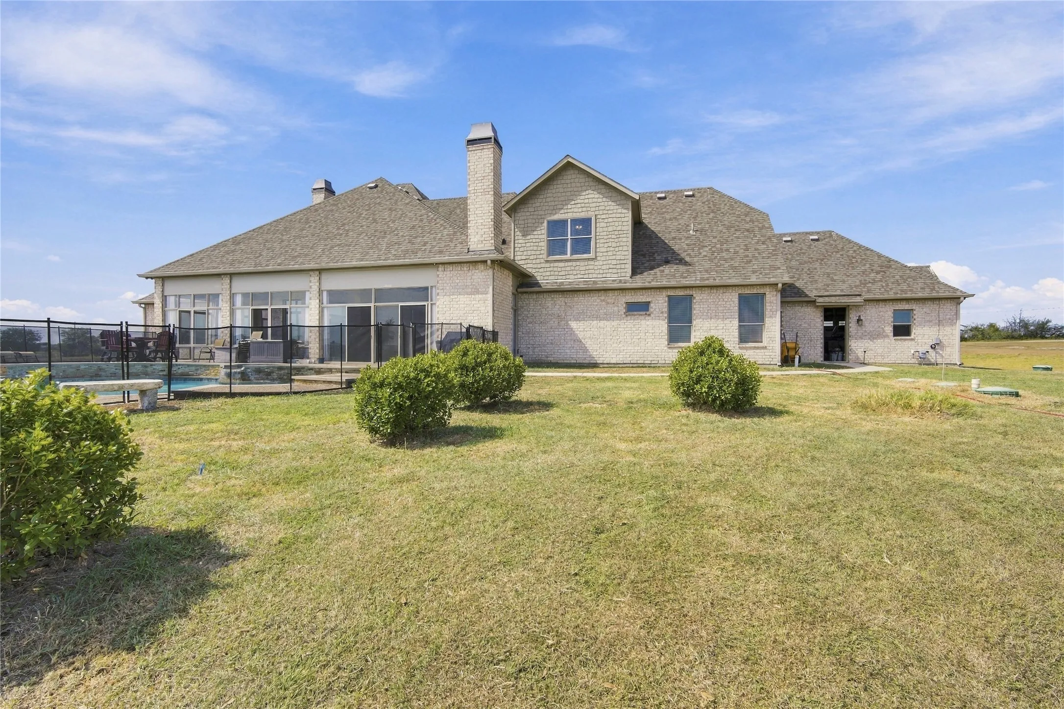 The rear exterior showcases classic brick construction with multiple chimneys and a striking gabled roofline.