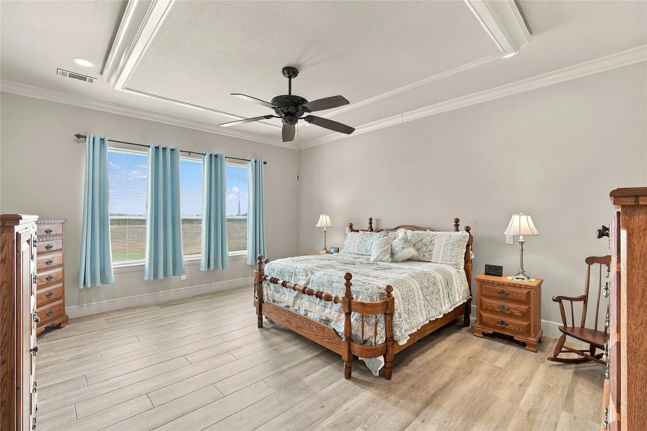 Unwind in the spacious primary suite, complete with a tray ceiling, crown molding, and abundant natural light.