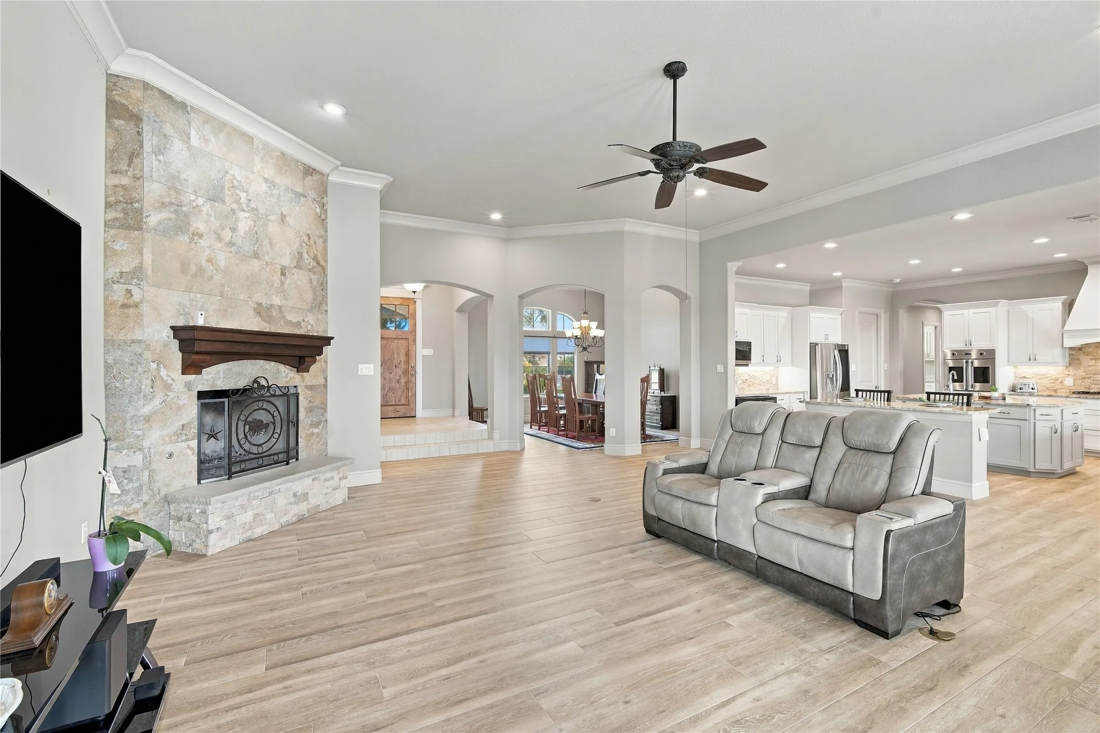 Another look at the fireplace-anchored living space, finished with crown molding and warm tile flooring throughout.