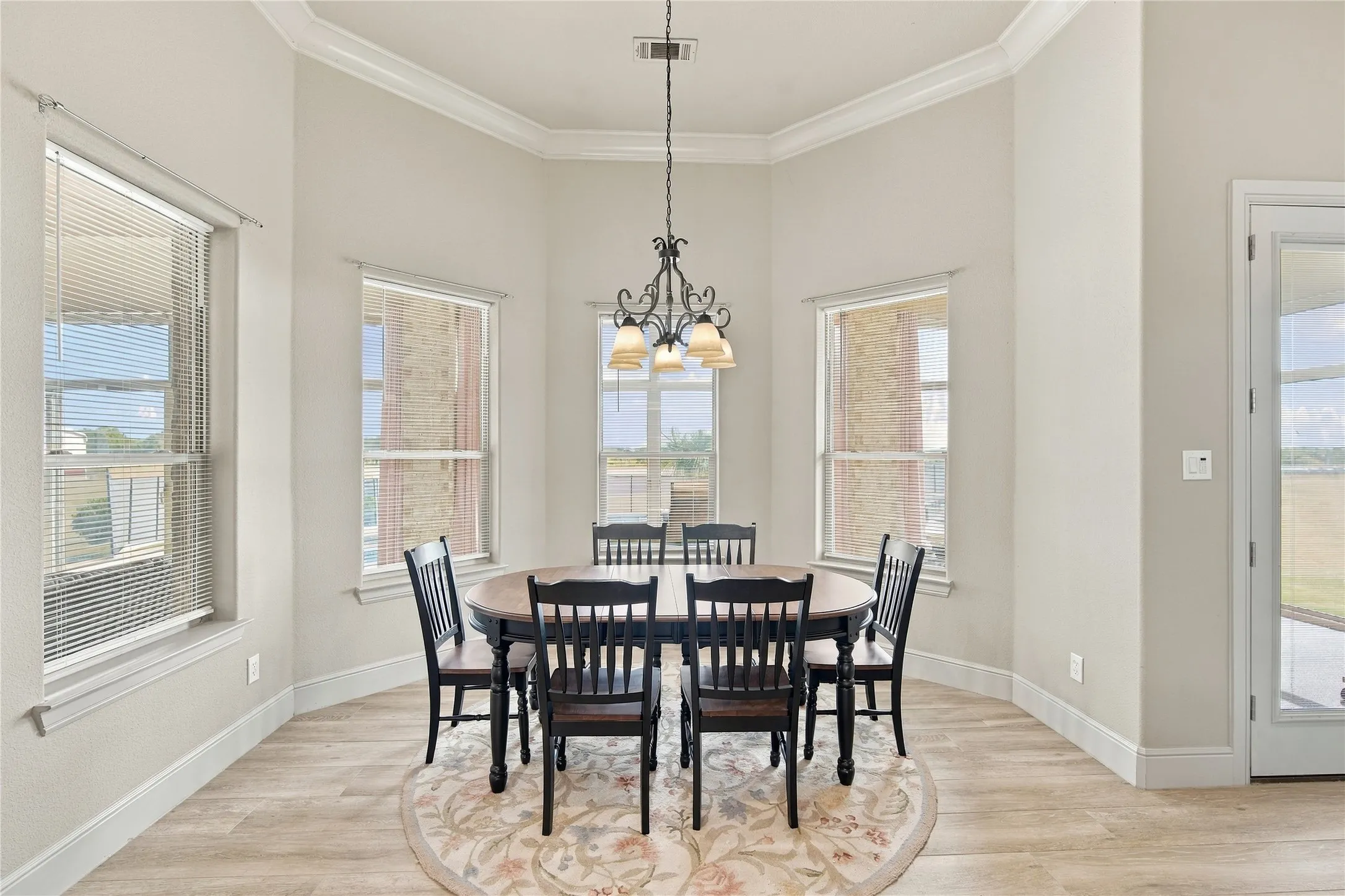 A sunlit dining nook framed by a bay window, ideal for morning coffee or casual meals with a view.