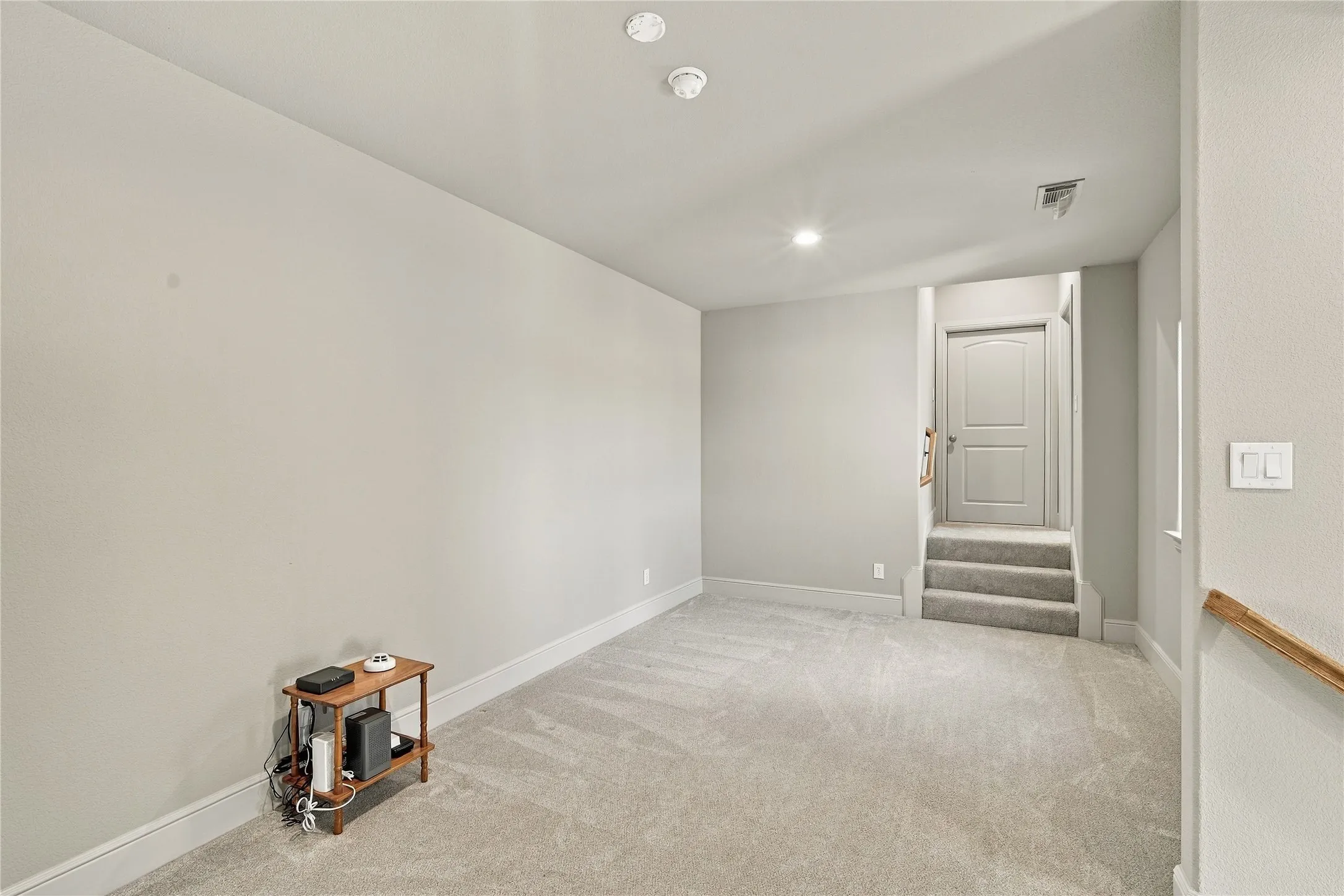 Plush carpet and neutral tones carry through this upstairs hallway, tying the bedrooms together with a warm, cohesive feel.
