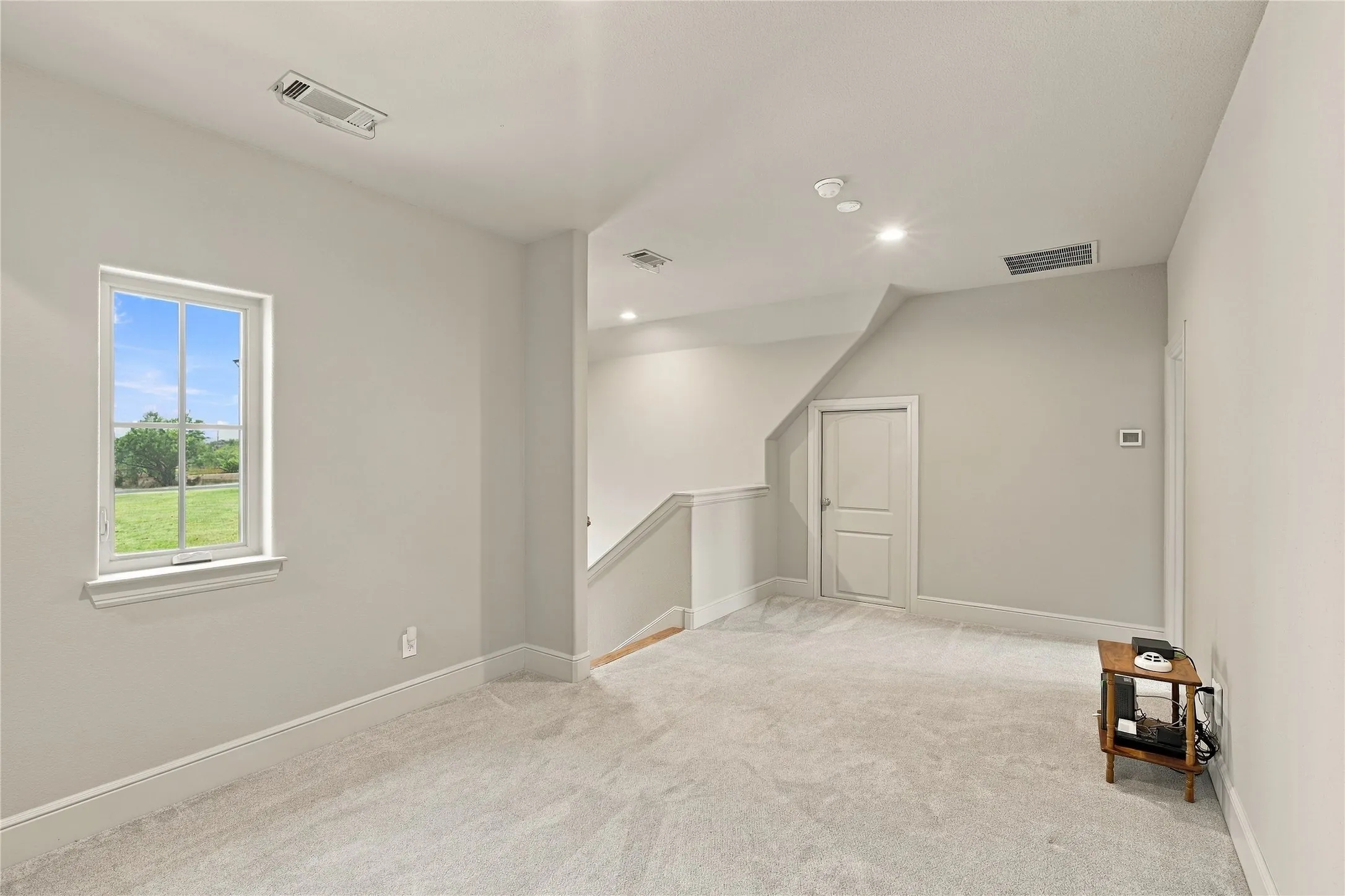 A sunlit upstairs hallway connects the staircase to the additional bedrooms, offering a bright, welcoming pass-through.