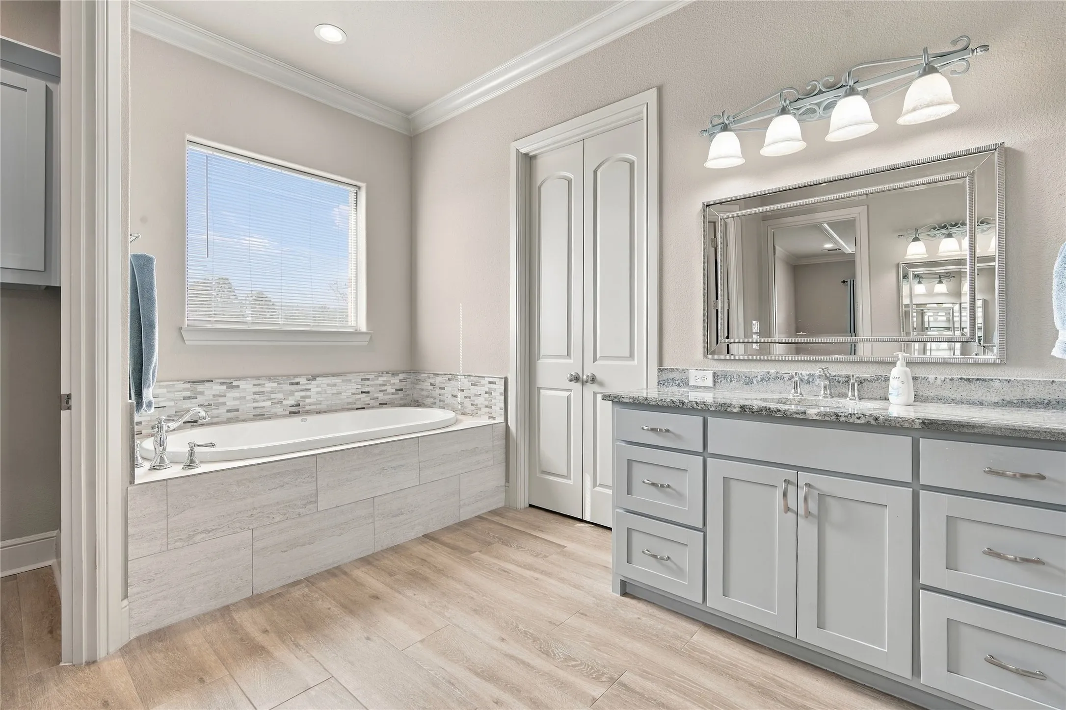 Soak away the day in the built-in tub with tiled surround, or get ready at the dual vanity in this spa-inspired primary bath.