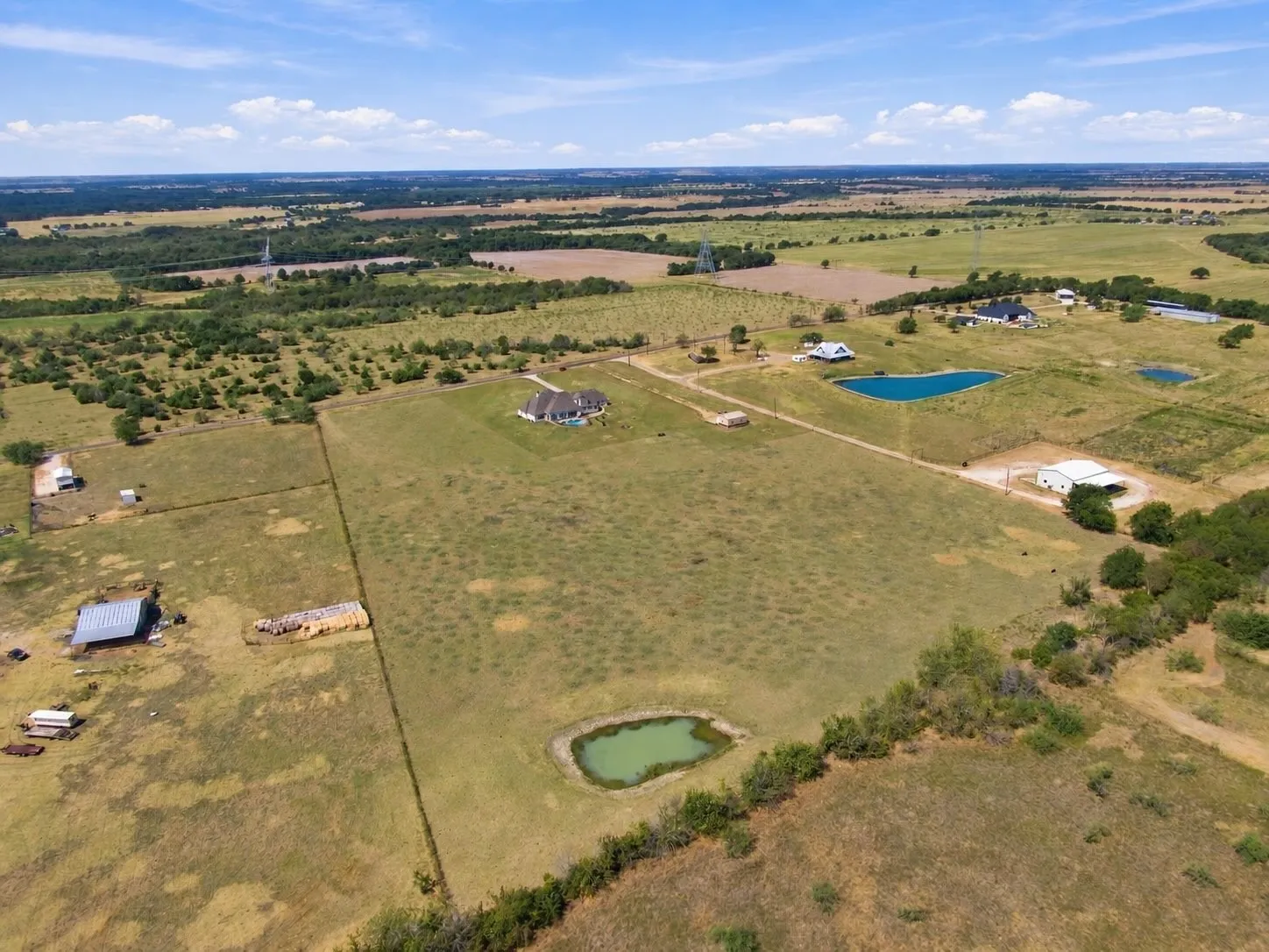 Rolling, natural terrain surrounds the home and its outbuildings, with two ponds adding to the picturesque setting.