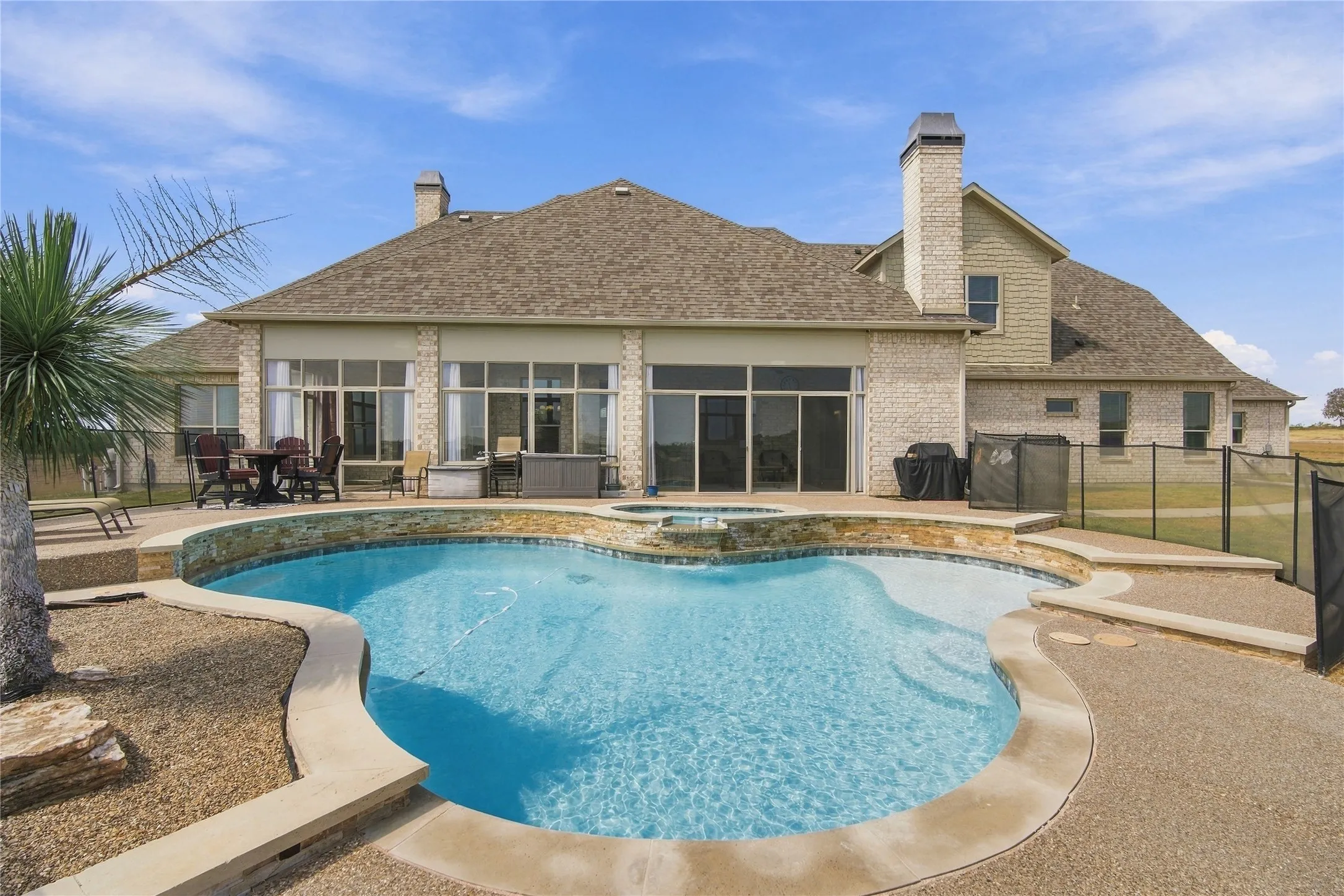 Your private backyard oasis awaits, a freeform pool and spa surrounded by a spacious patio, perfect for swimming, lounging, or hosting unforgettable gatherings.