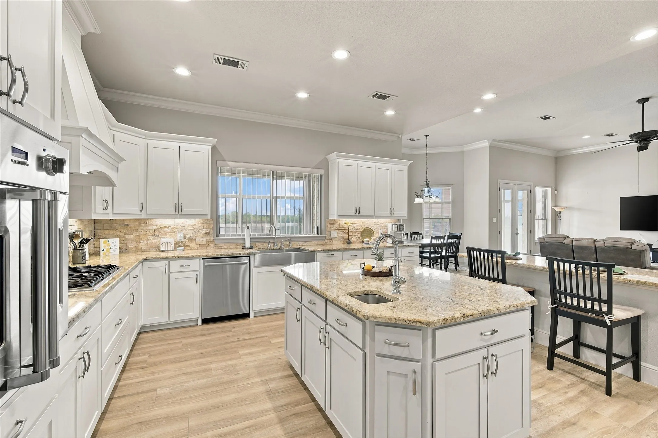 A closer look at the well-appointed kitchen, with a center island sink, sleek countertops, and crisp white cabinetry.
