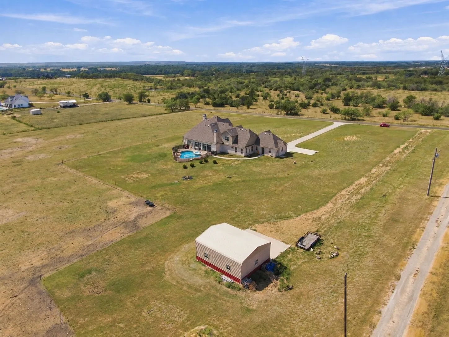 A bird's-eye view capturing the pool, home, and outbuilding together, showing just how much this property has to offer.