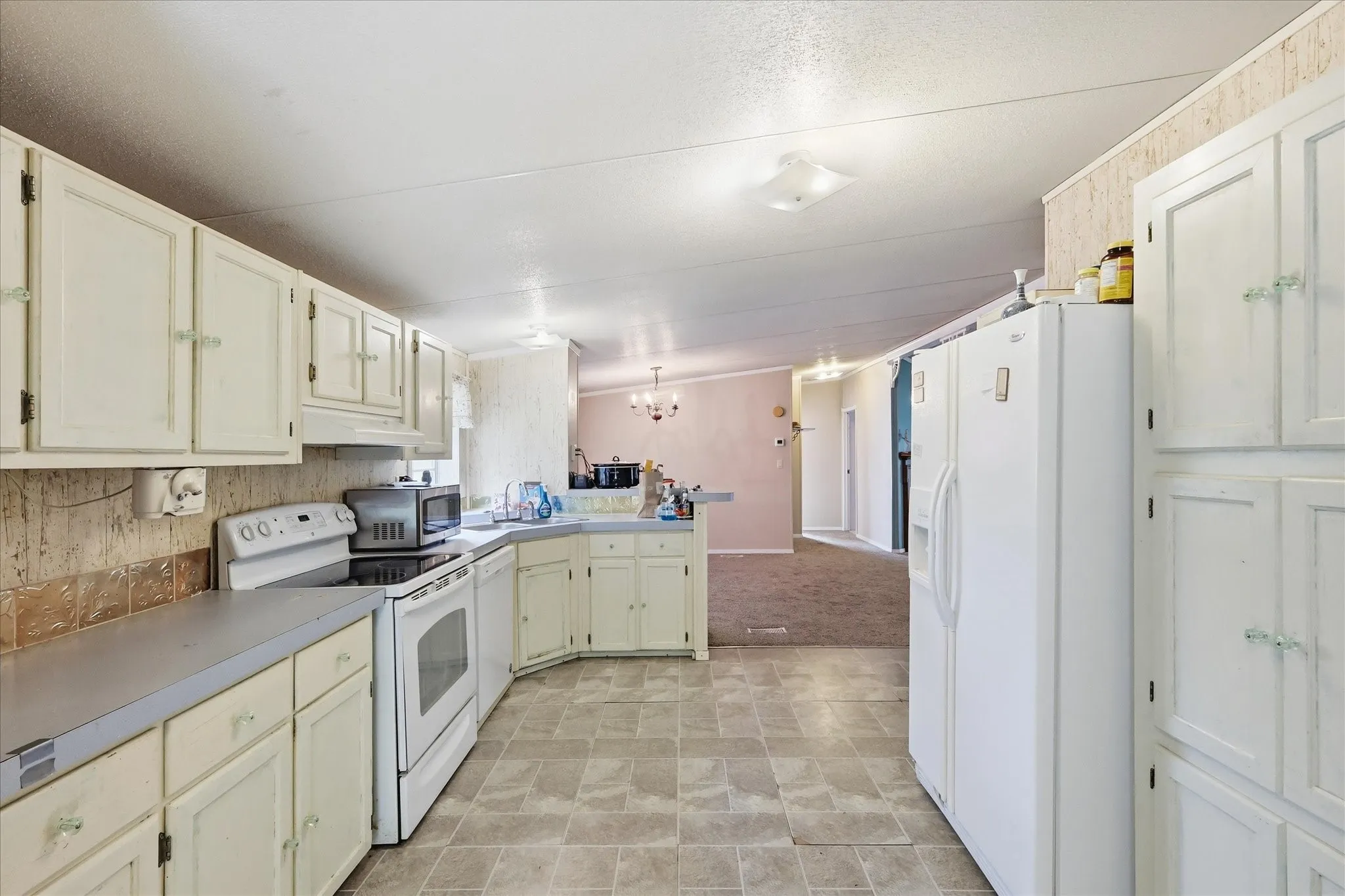 Kitchen featuring white cabinetry, tile flooring, and laminate countertops