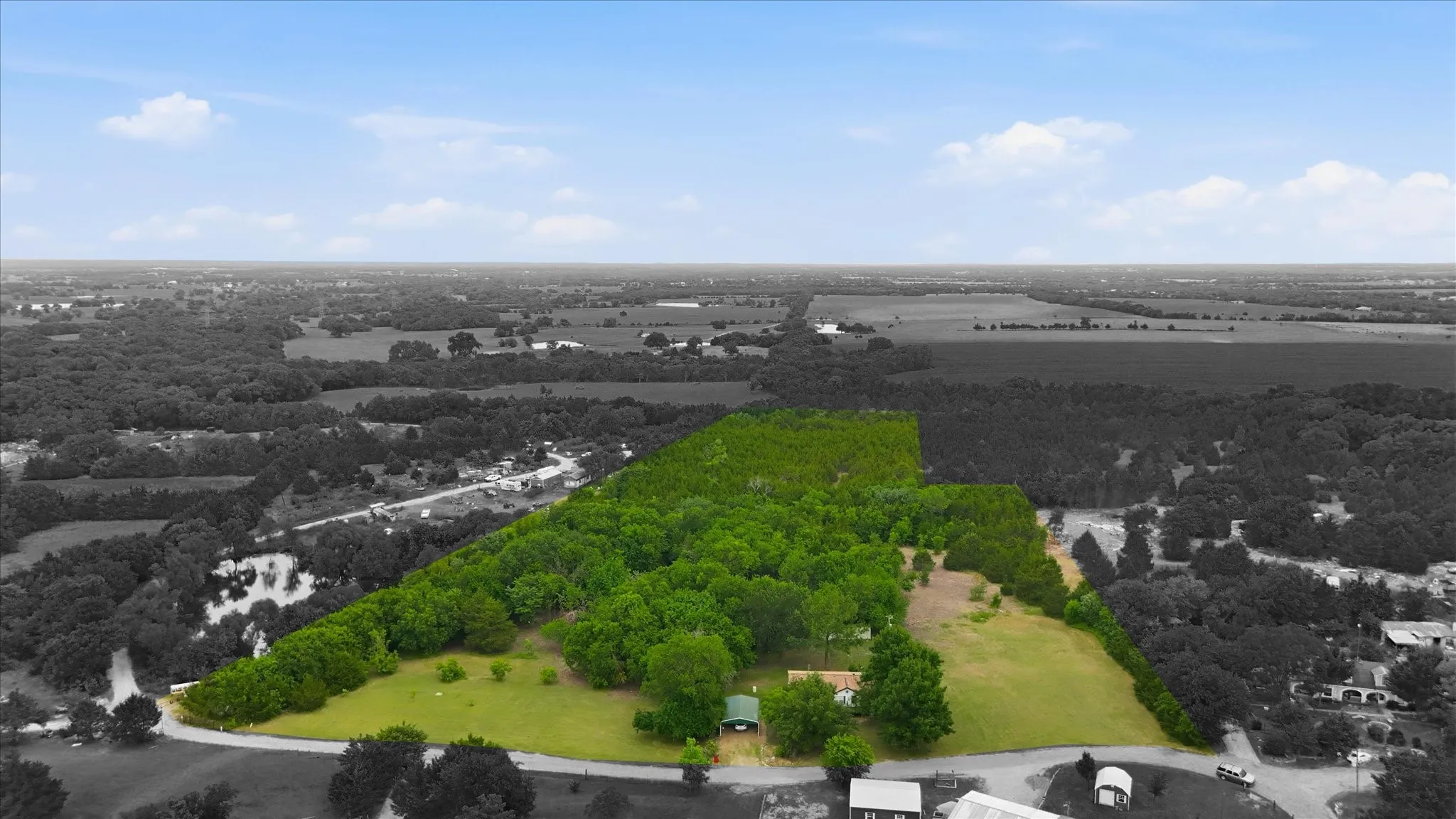 Expansive land parcel featuring a mix of cleared areas and mature trees
