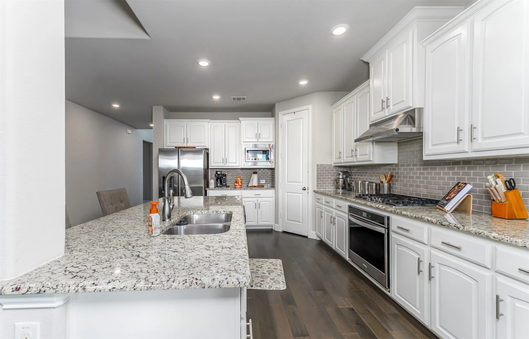 White cabinetry and a mosaic tile backsplash highlight this kitchen