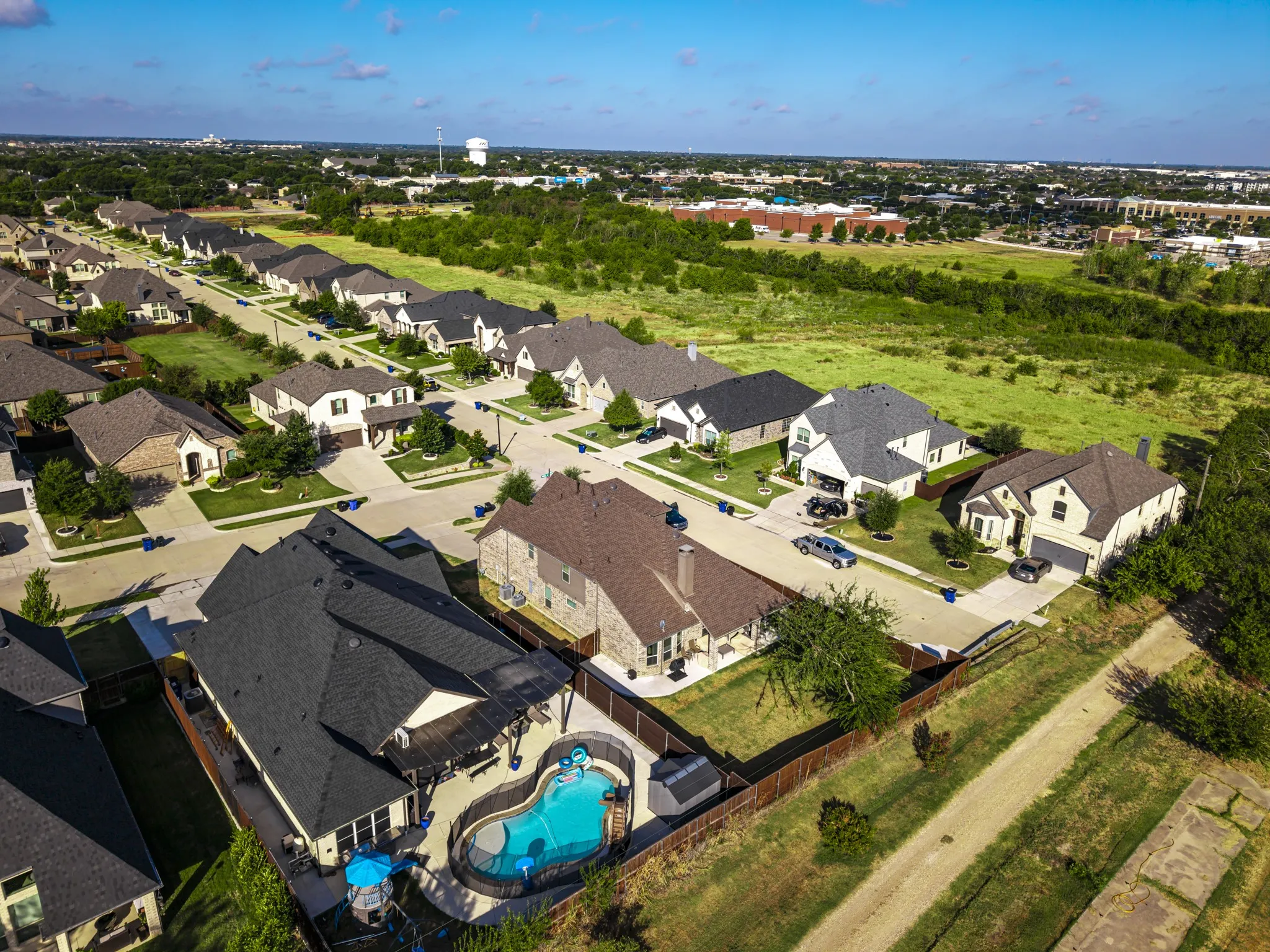 Residential neighborhood featuring single-family homes with pitched roofs, front-facing garages, and landscaped front yards