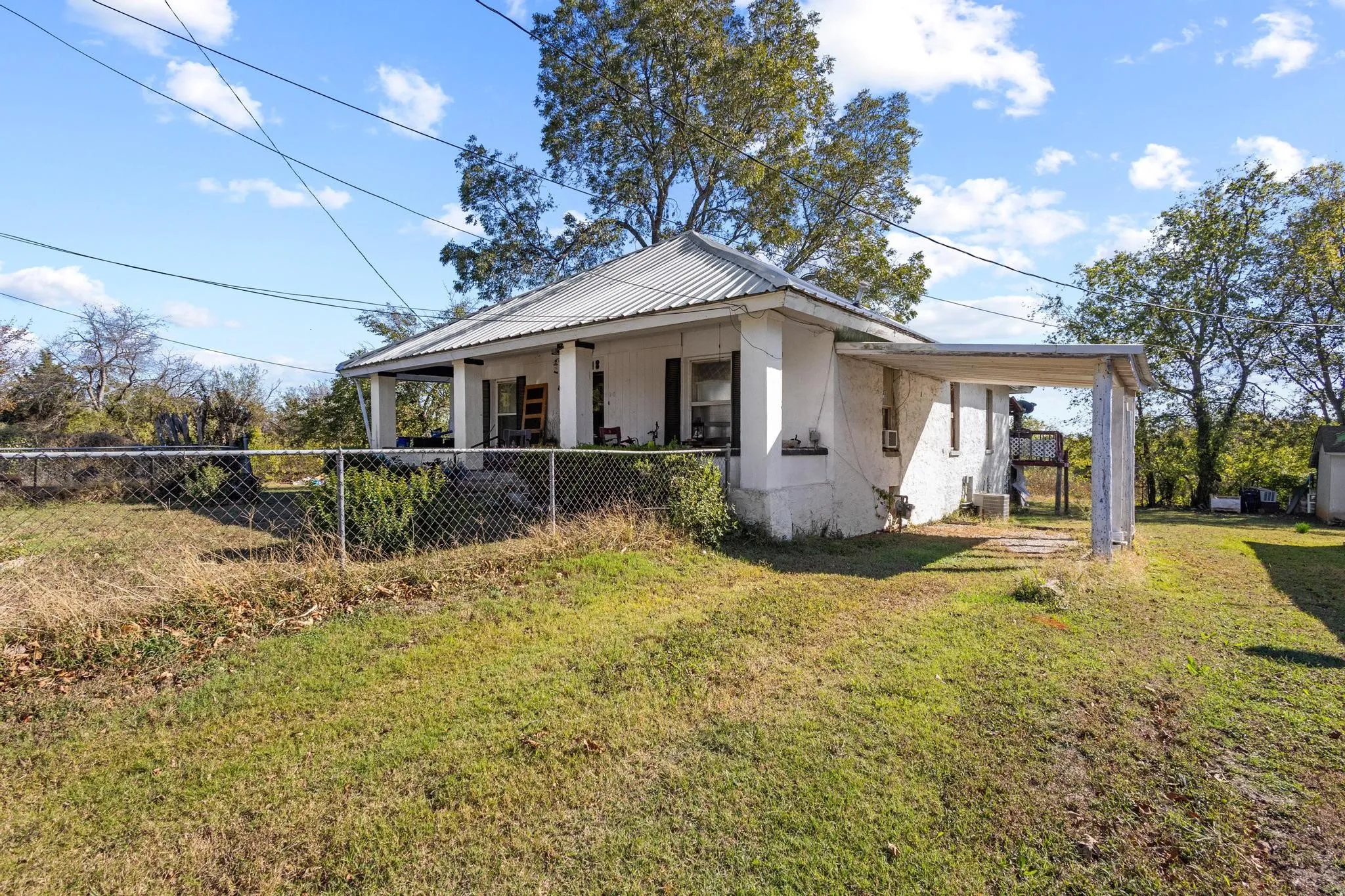 Traditional exterior with a covered front porch, metal roof, and an attached carport