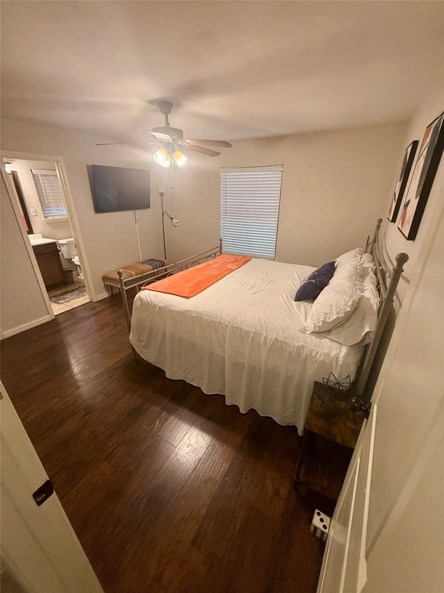 Wood-finish flooring throughout, ceiling fan with integrated lighting, and window with blinds