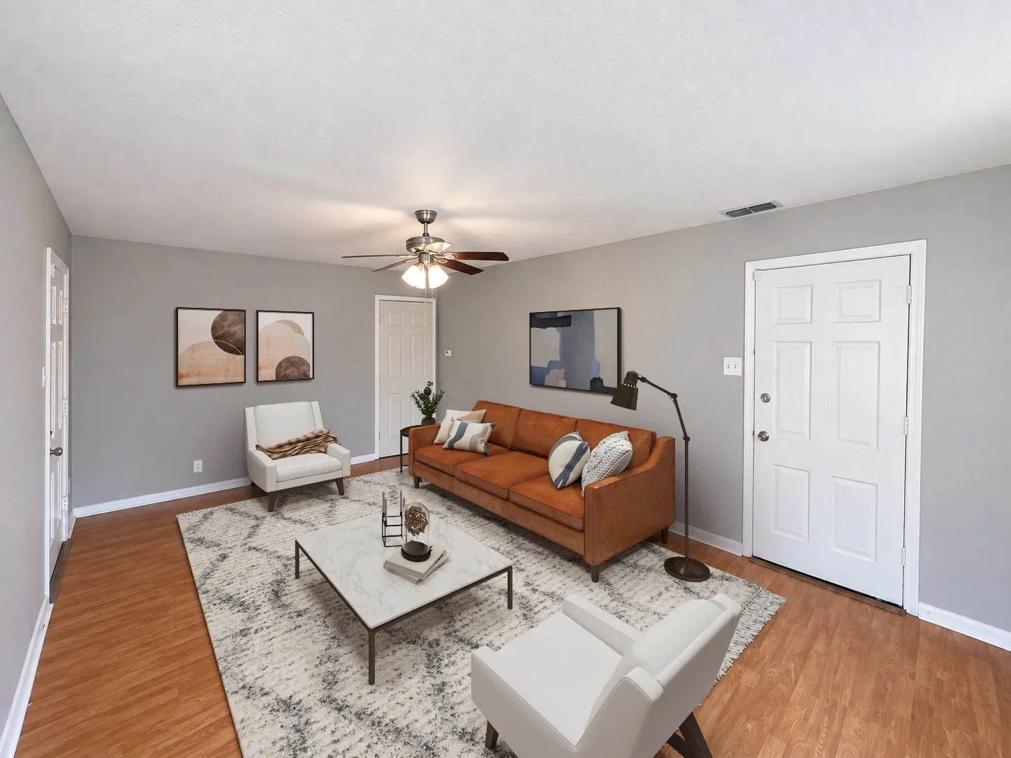 Virtually staged -
Spacious room featuring wood-finish flooring, a ceiling fan with integrated lighting, and light gray wall finishes
