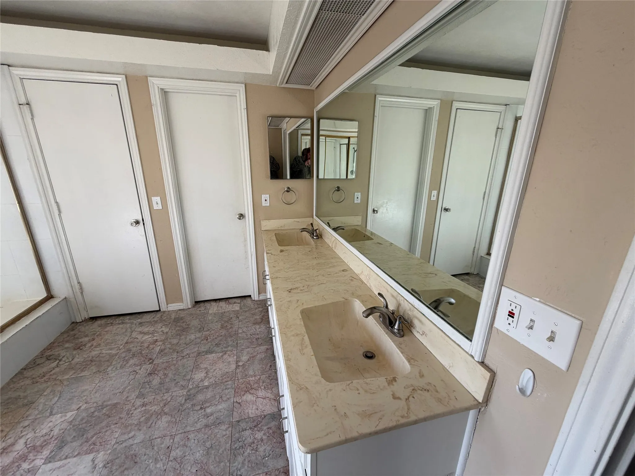 Dual vanity with integrated sinks, expansive mirror, and patterned floor tile