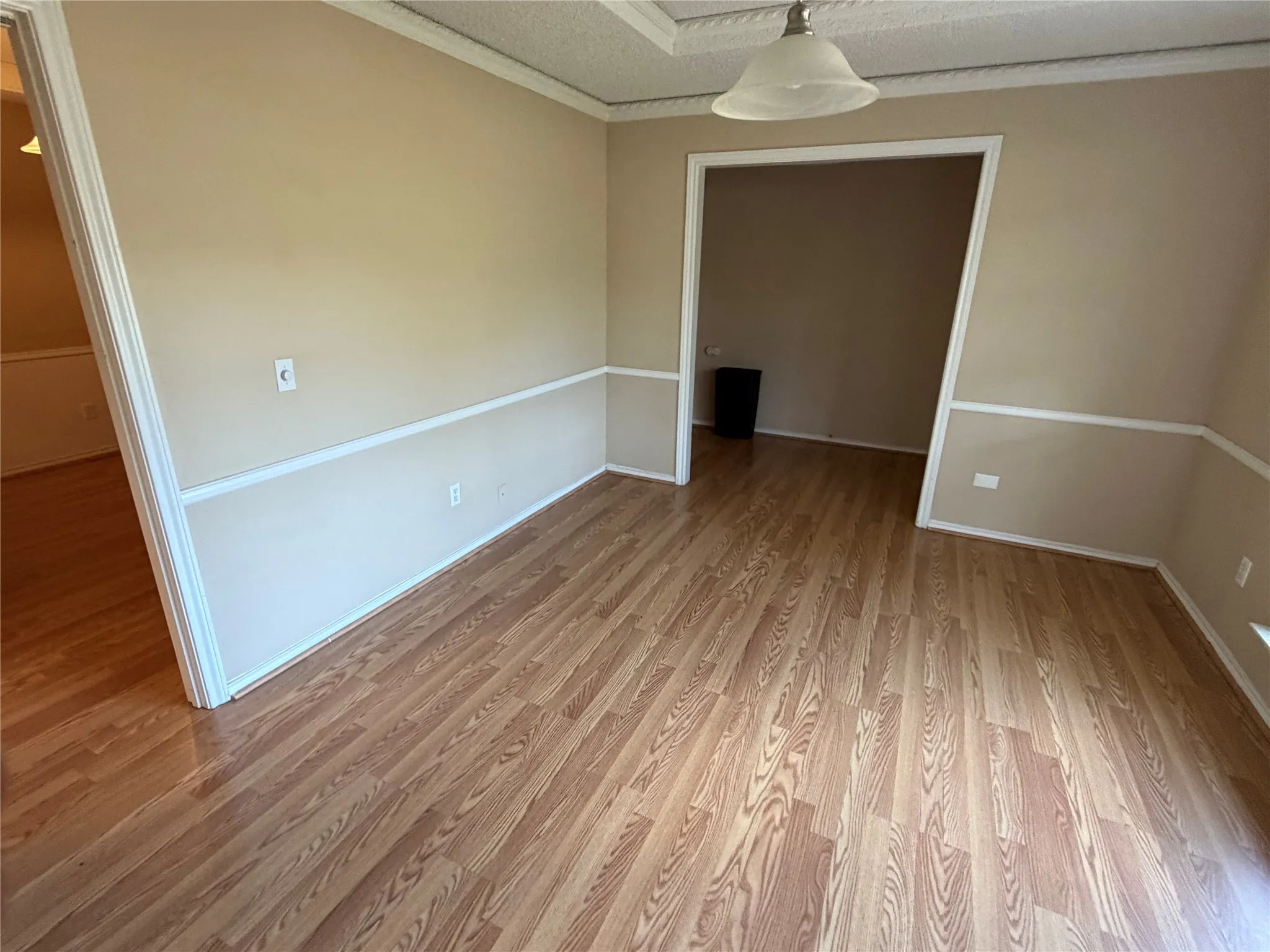 Wood-finish flooring throughout, chair rail detailing, and a neutral color palette
