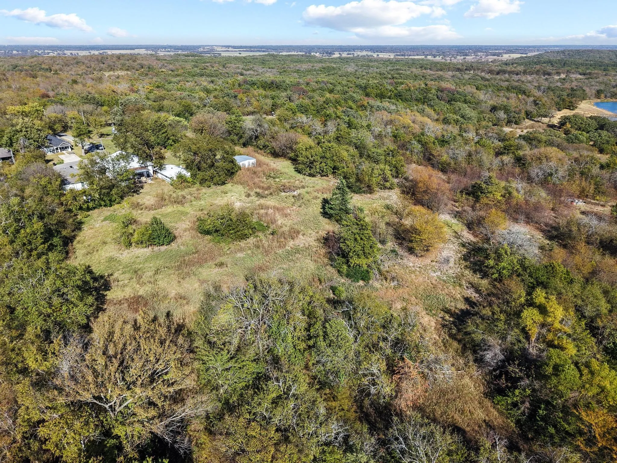Expansive land parcel with significant tree coverage and open grassy areas