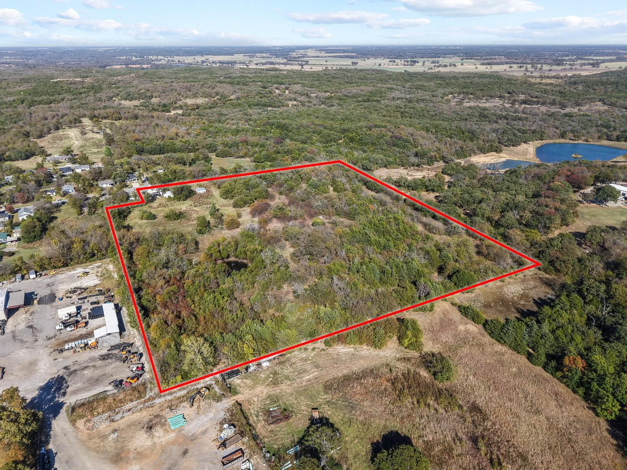 Expansive land parcel with varied topography, mature tree coverage, and open clearings