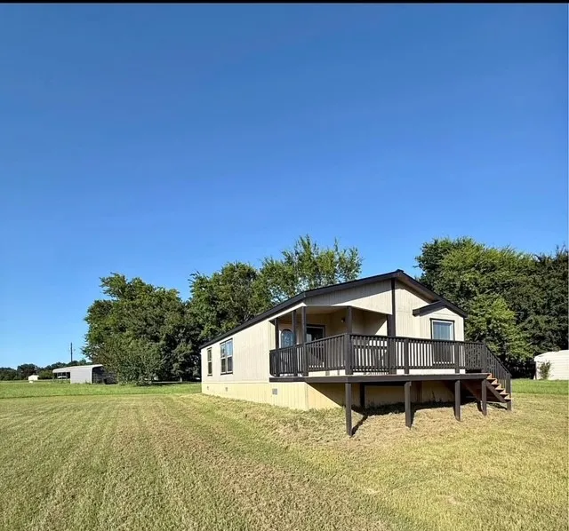 Featuring a yard, a wooden deck, and stairs