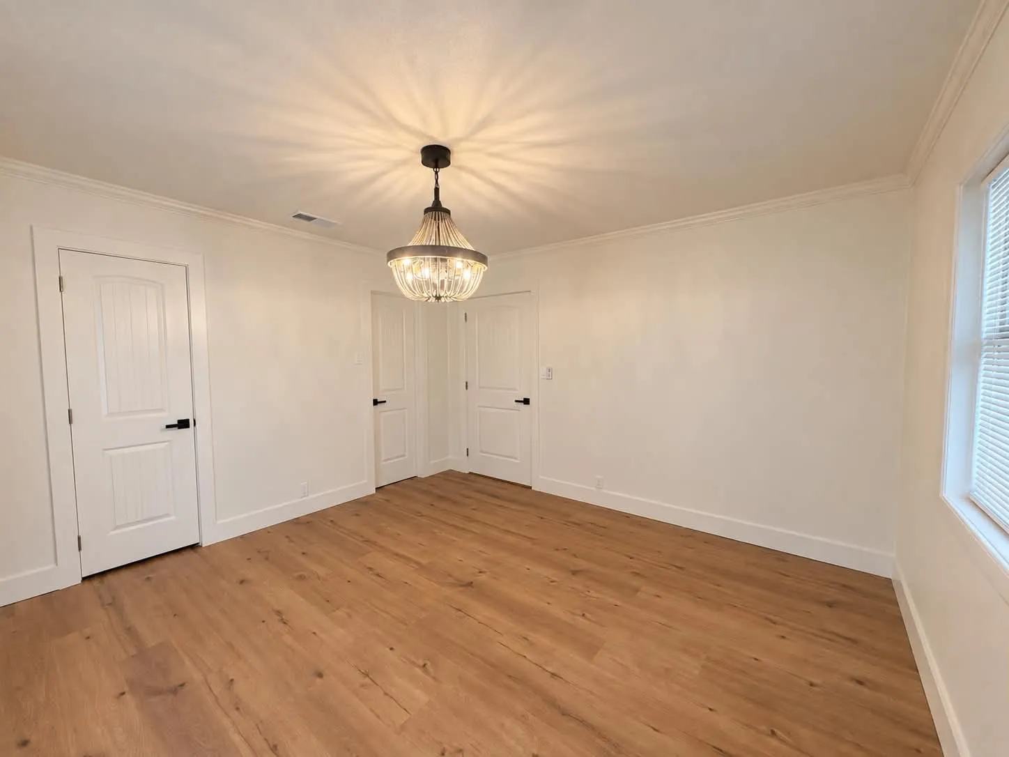 Primary bedroom featuring a "fandelier". Yep, that's a fan!