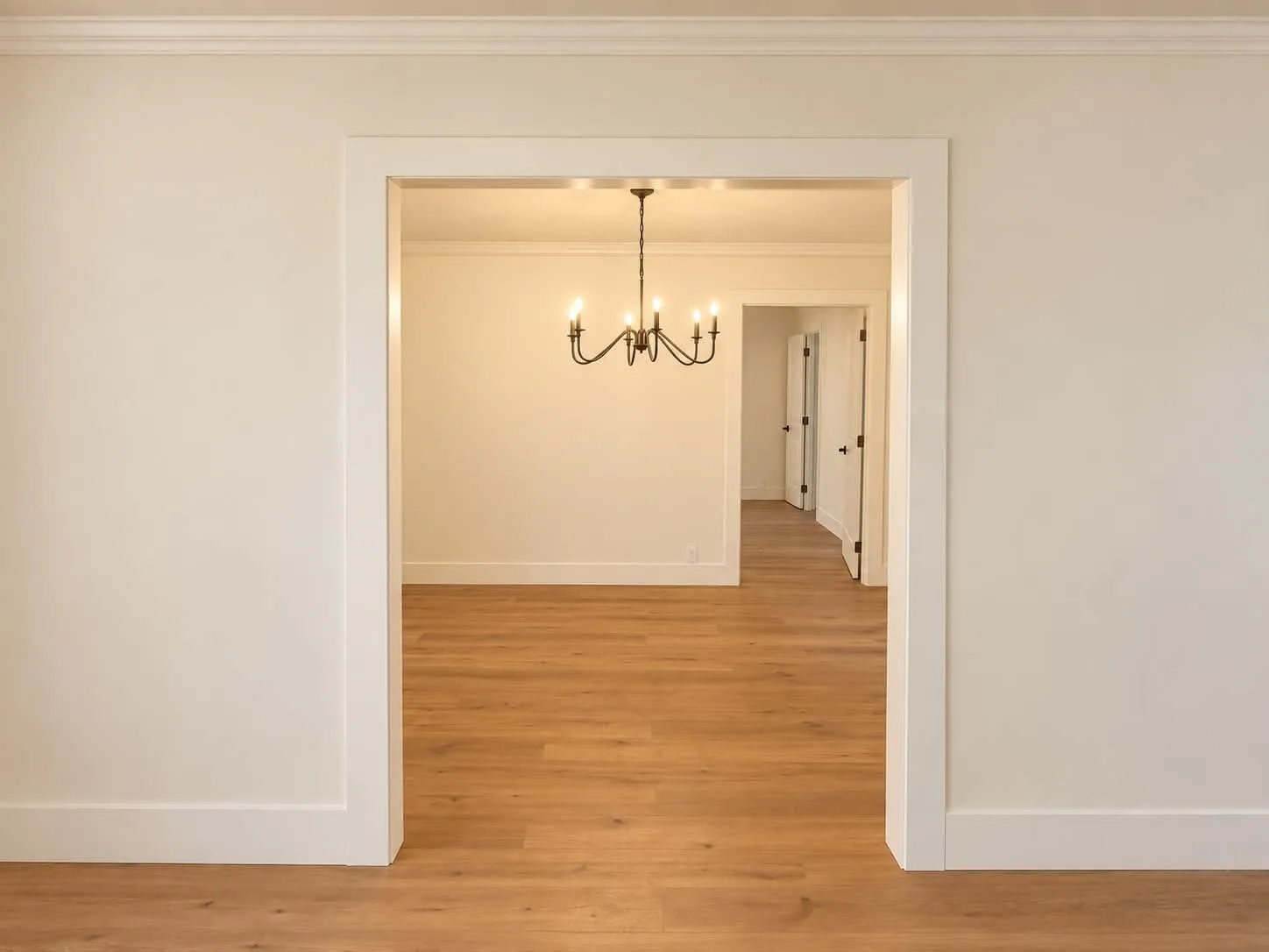 View from living room to dining room opening with chandelier.
