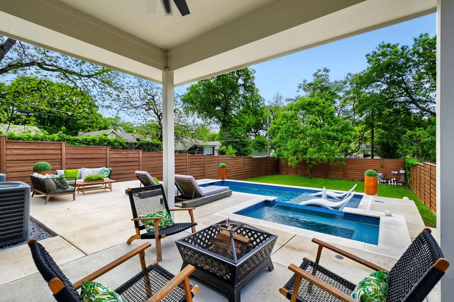 Integrated pool / hot tub featuring an outdoor living space with a fire pit, a patio area, and a fenced backyard