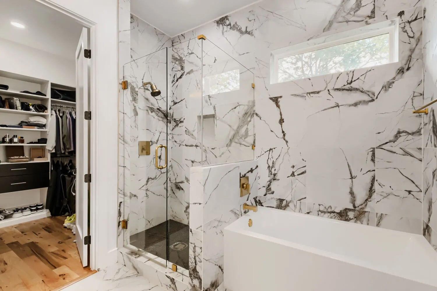Full bathroom featuring a bath, a marble finish shower, and a walk in closet