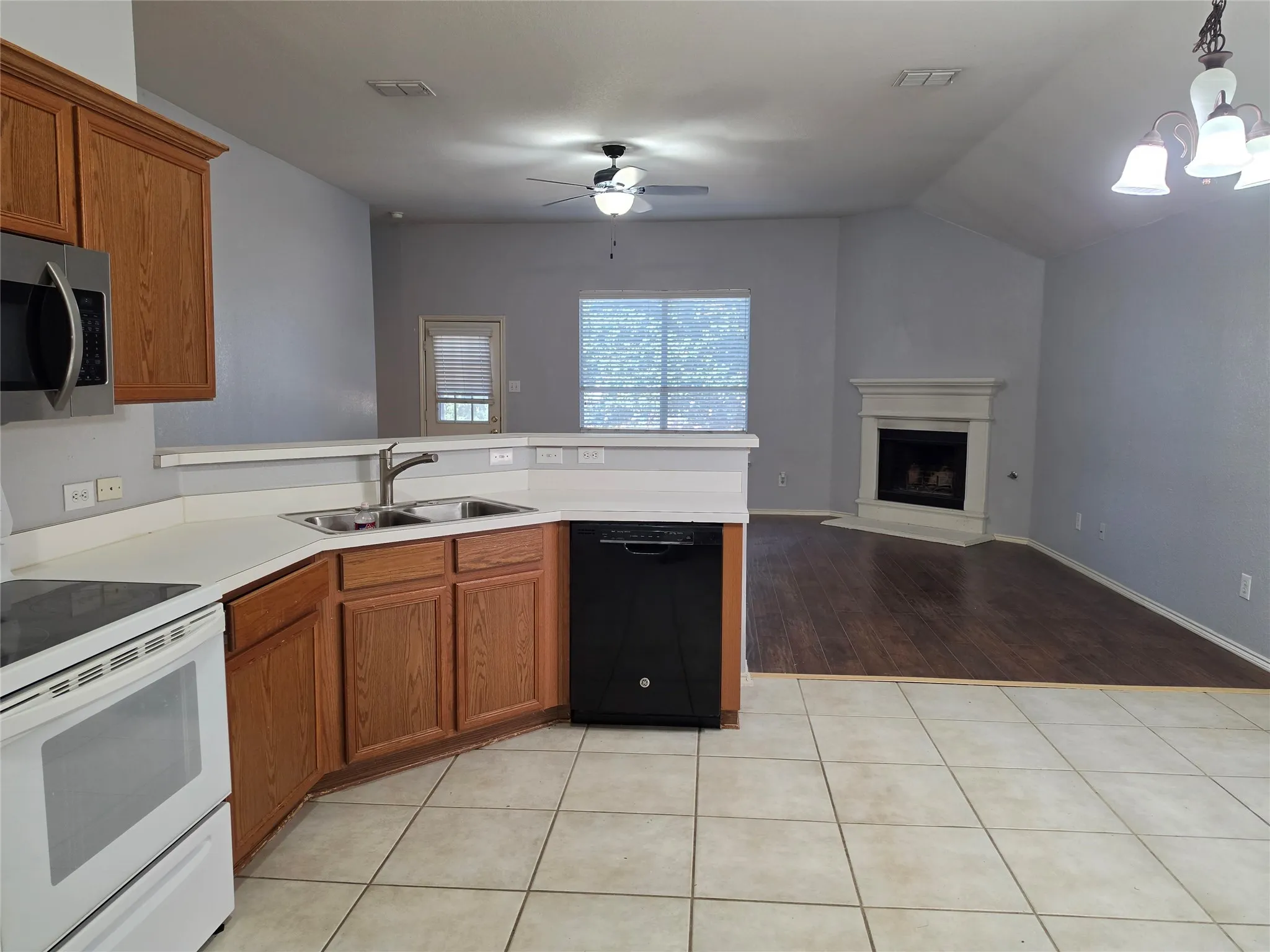 Kitchen featuring wood cabinetry, stainless steel microwave, and white countertops