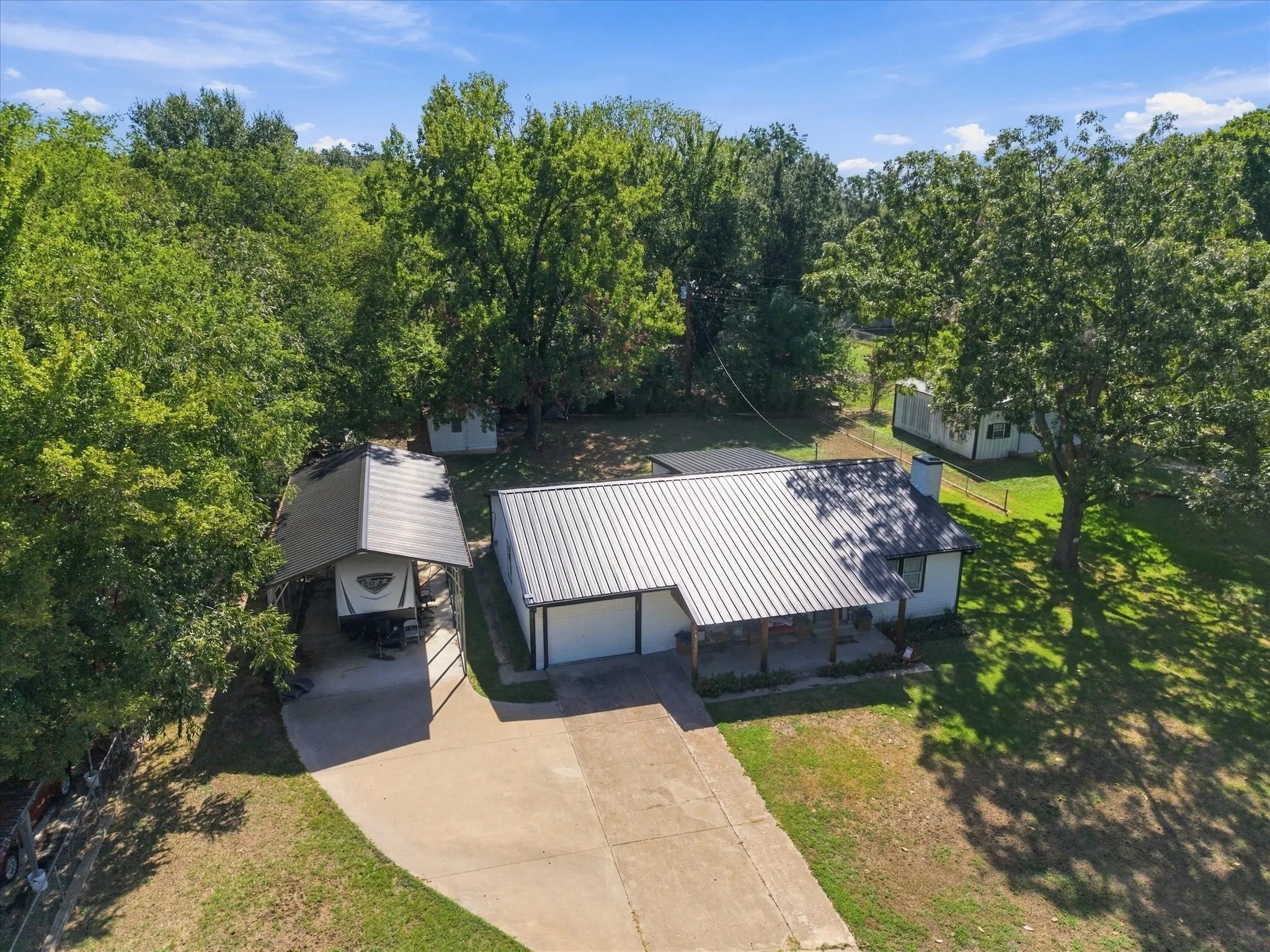Residence featuring a metal roof, attached two-car garage, and covered front porch