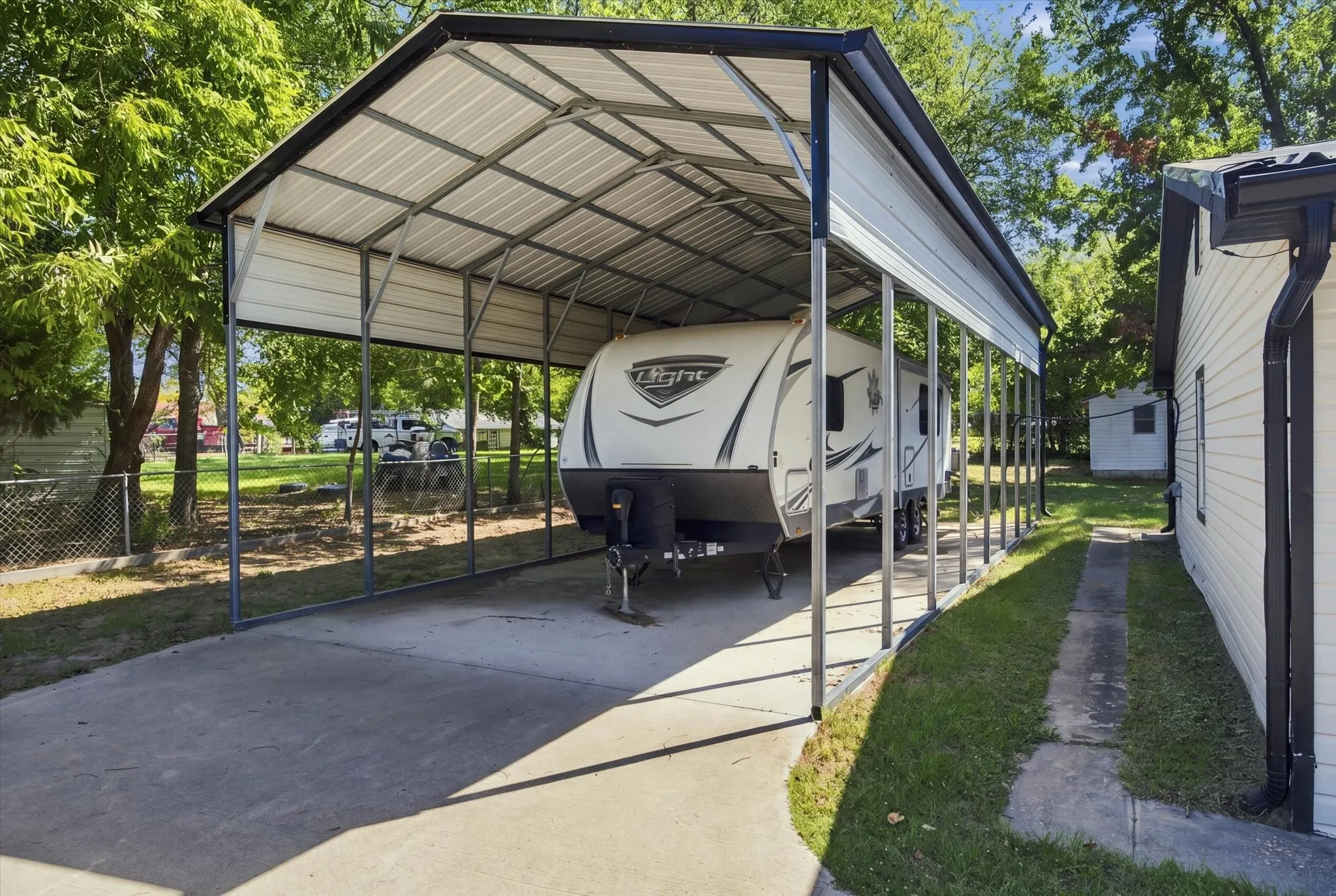 Covered carport structure with a concrete pad and exposed metal framing