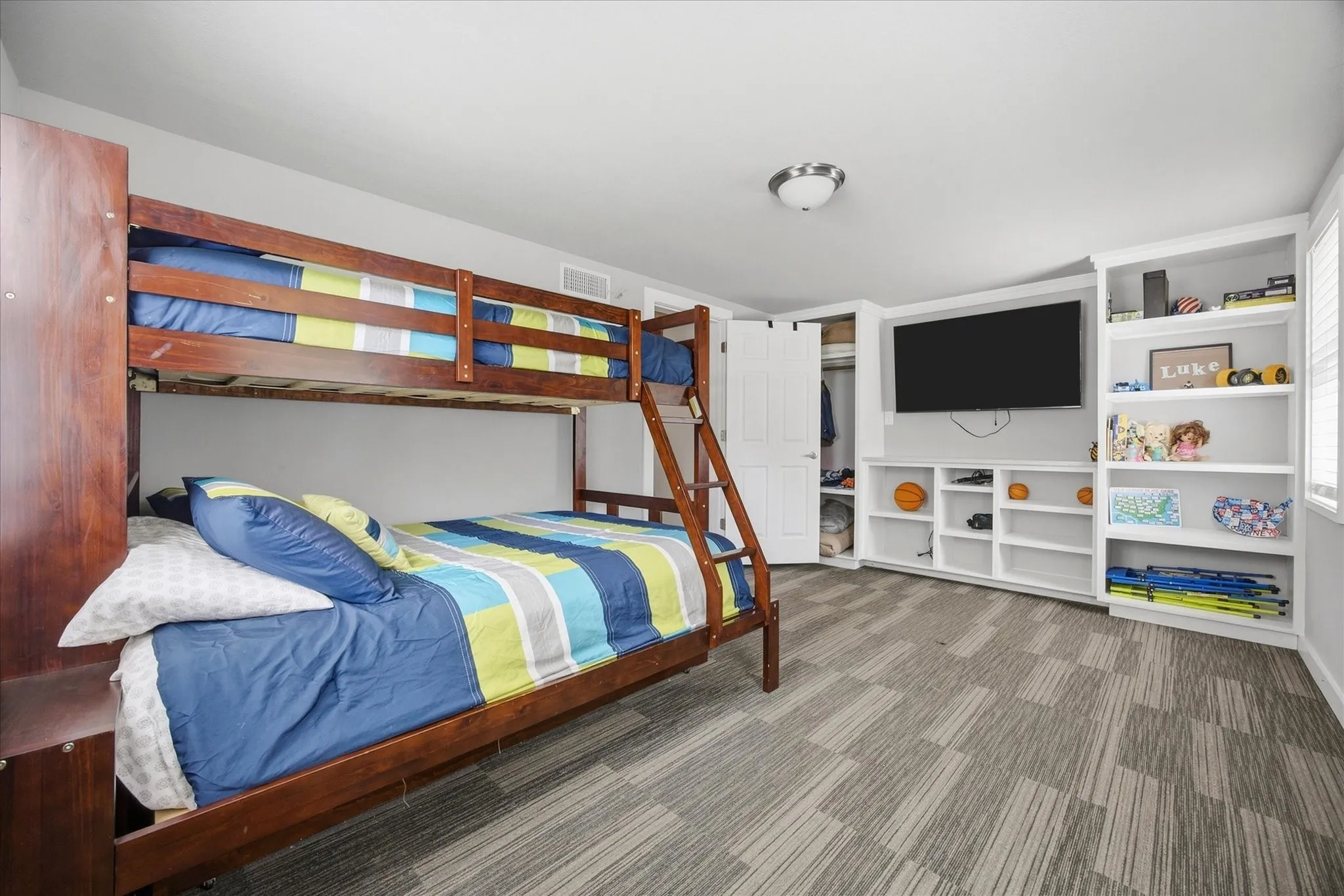 Built-in entertainment center with shelving, recessed lighting, and wall-mounted television space