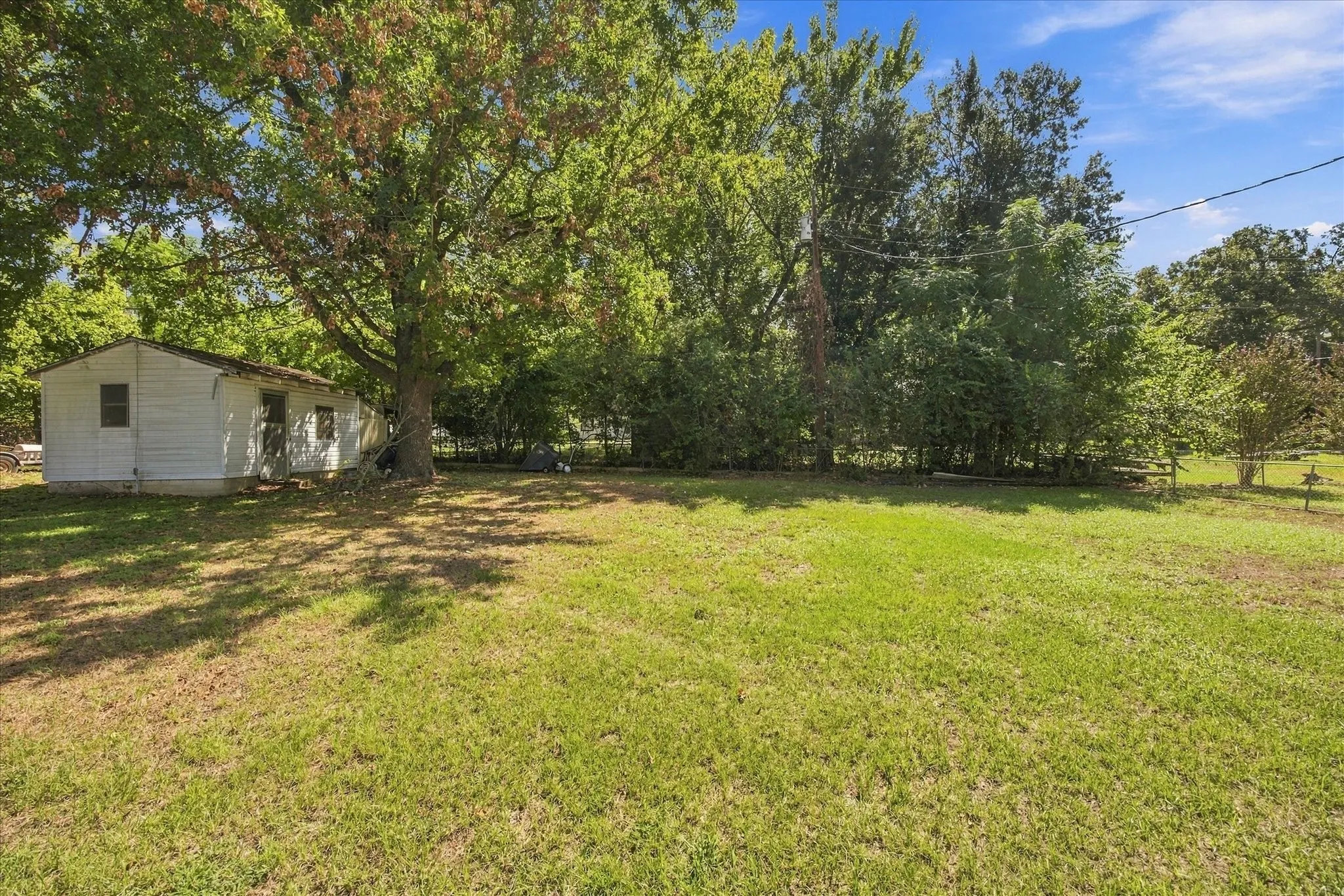 Expansive grassy yard with mature trees