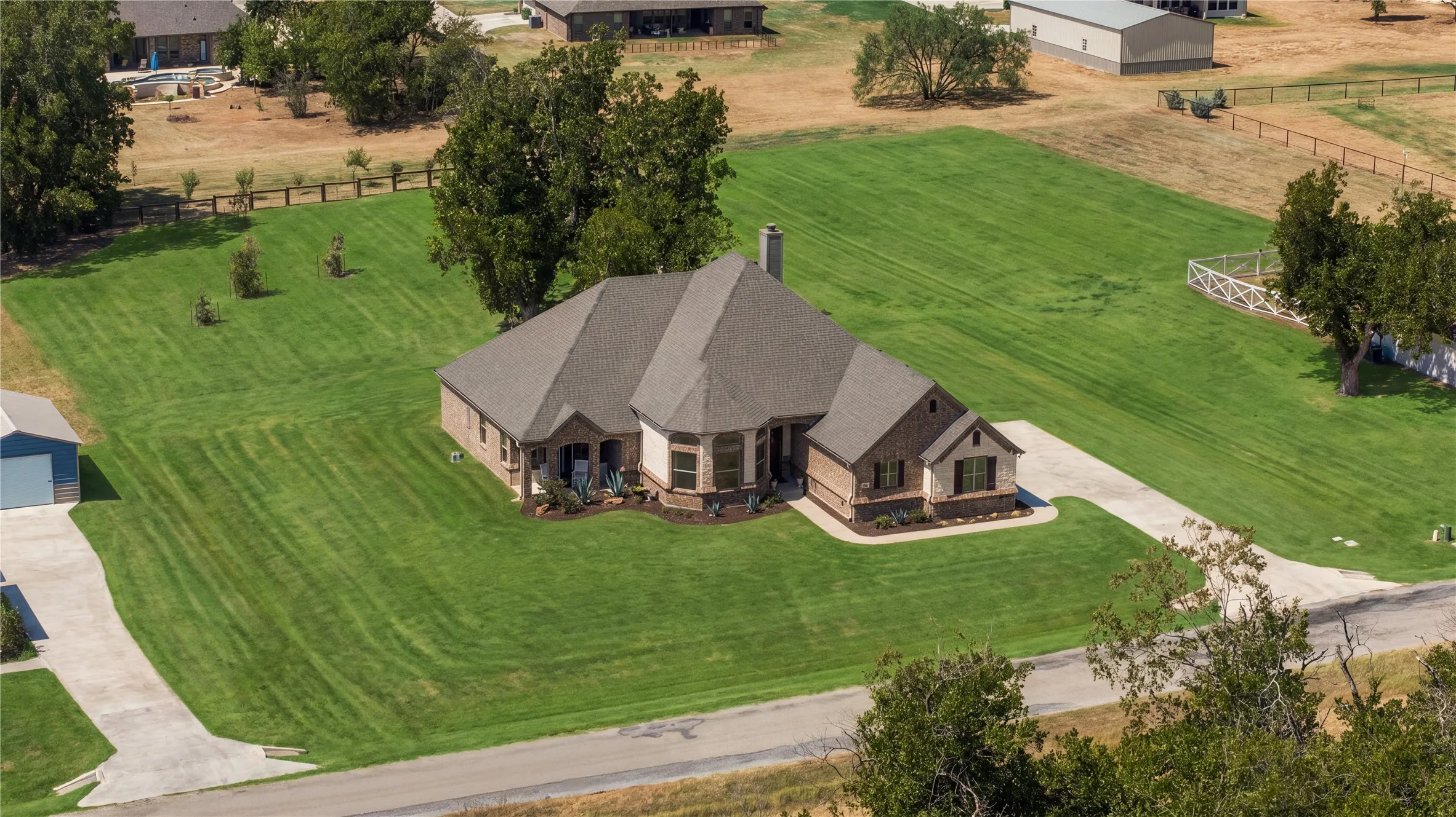 Mature Pecan trees frame the residence and reinforce one of the property's defining advantages: newer construction without a newly planted landscape.