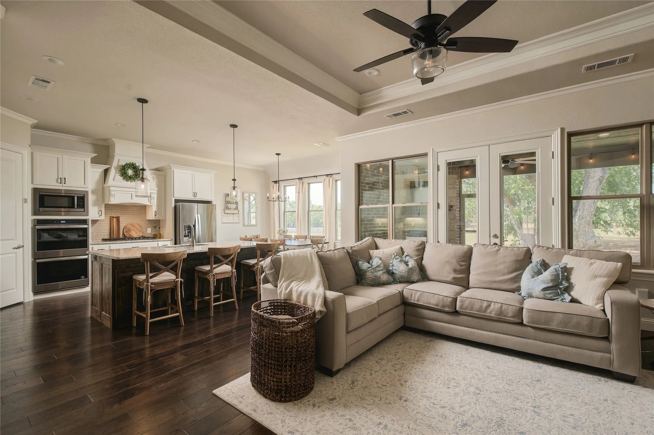 Designed for gathering, the open living area connects seamlessly with the kitchen while large windows bring the one acre setting indoors