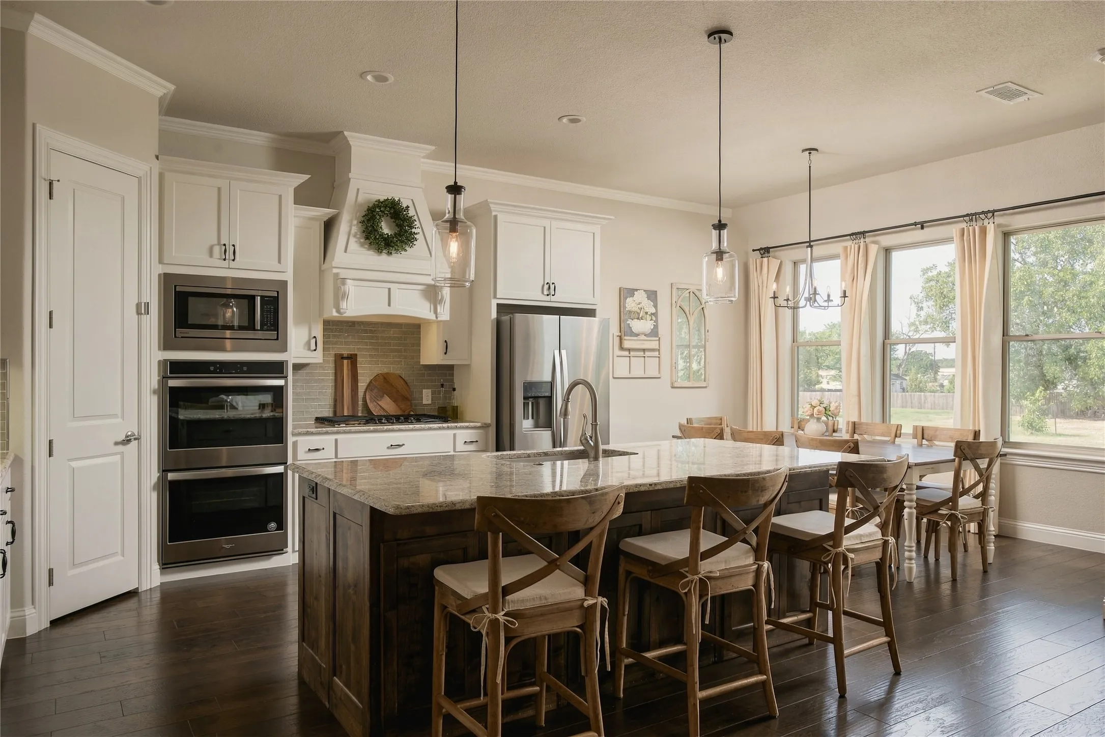 An oversized island anchors the kitchen with abundant prep space, casual seating and an easy connection to the living and dining areas.
