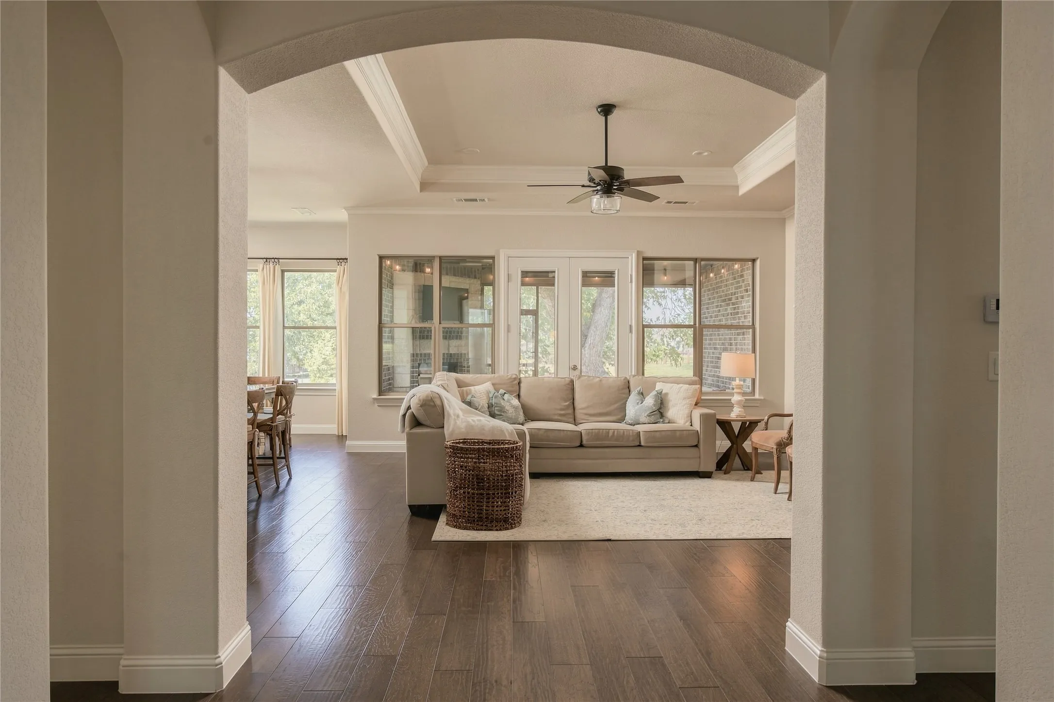 Arched openings create an elegant transition into the main living spaces while preserving an open, connected feel.