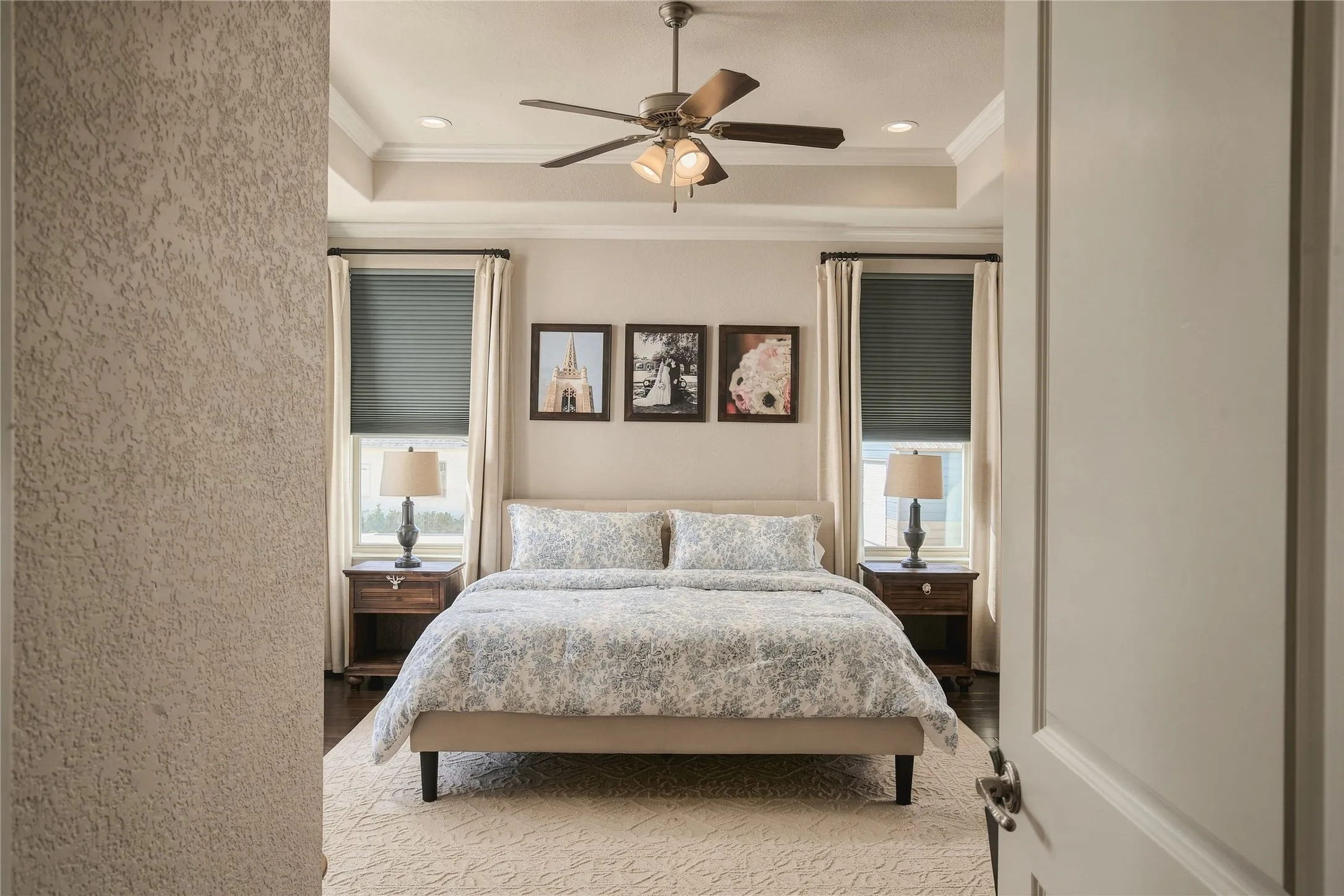 The owner’s suite feels intentionally removed from the pace of the home, creating a private retreat with hardwood floors, elevated ceiling detail and a peaceful connection to the property.