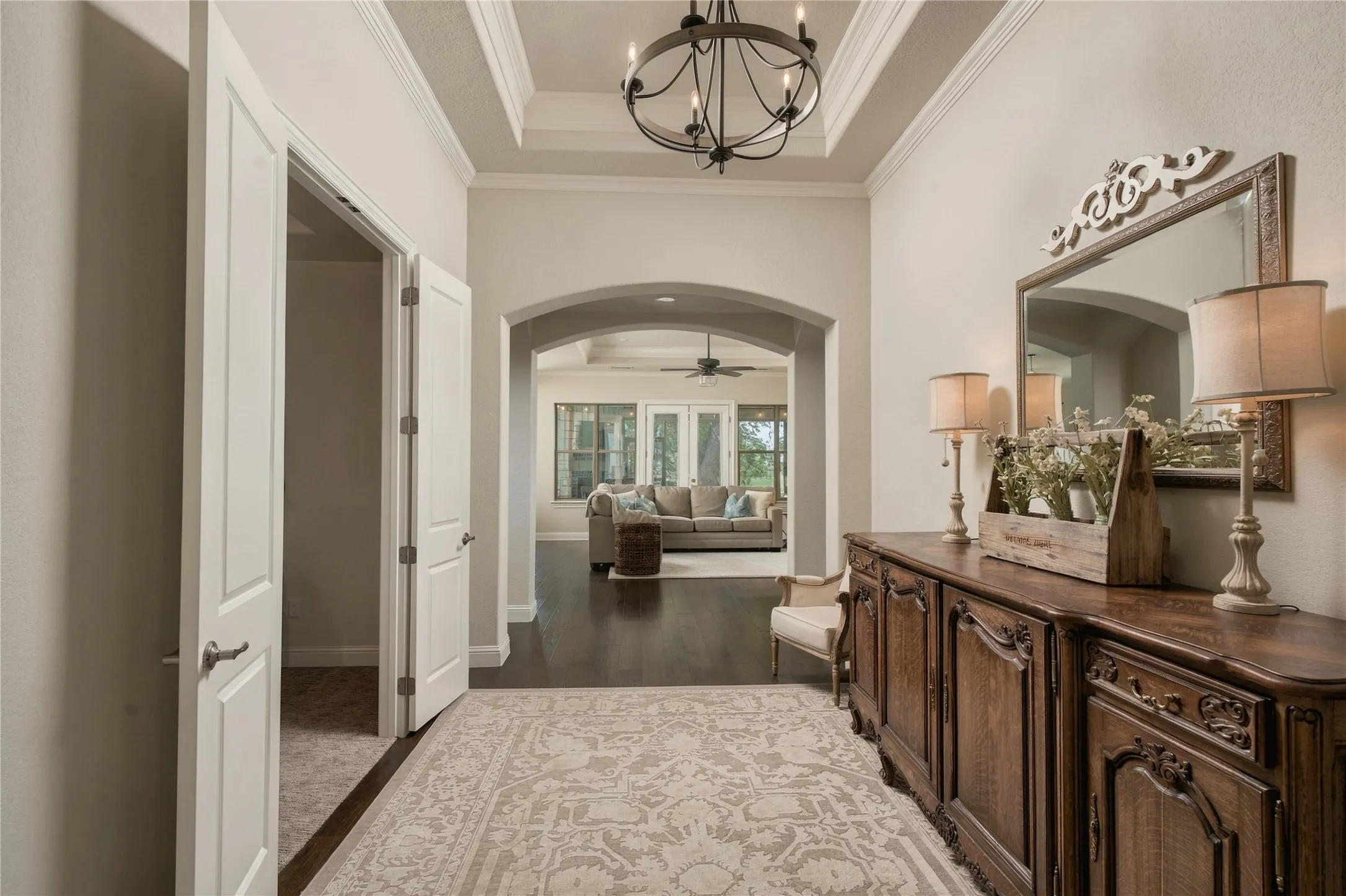 Architectural ceiling detail, crown molding and hardwood flooring elevate the arrival experience beyond a typical newer-build entry.