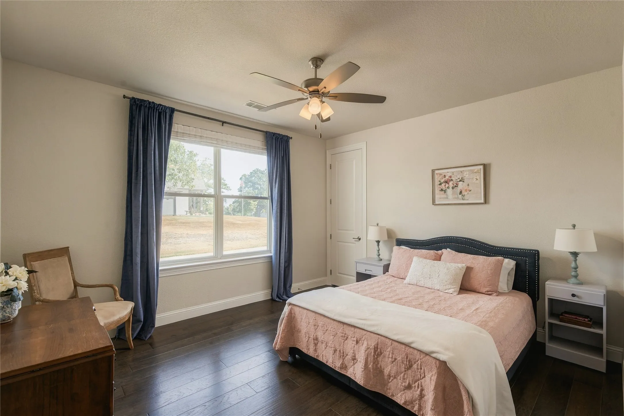 An expansive window brings abundant daylight and green views into this secondary bedroom, creating a bright and comfortable retreat.