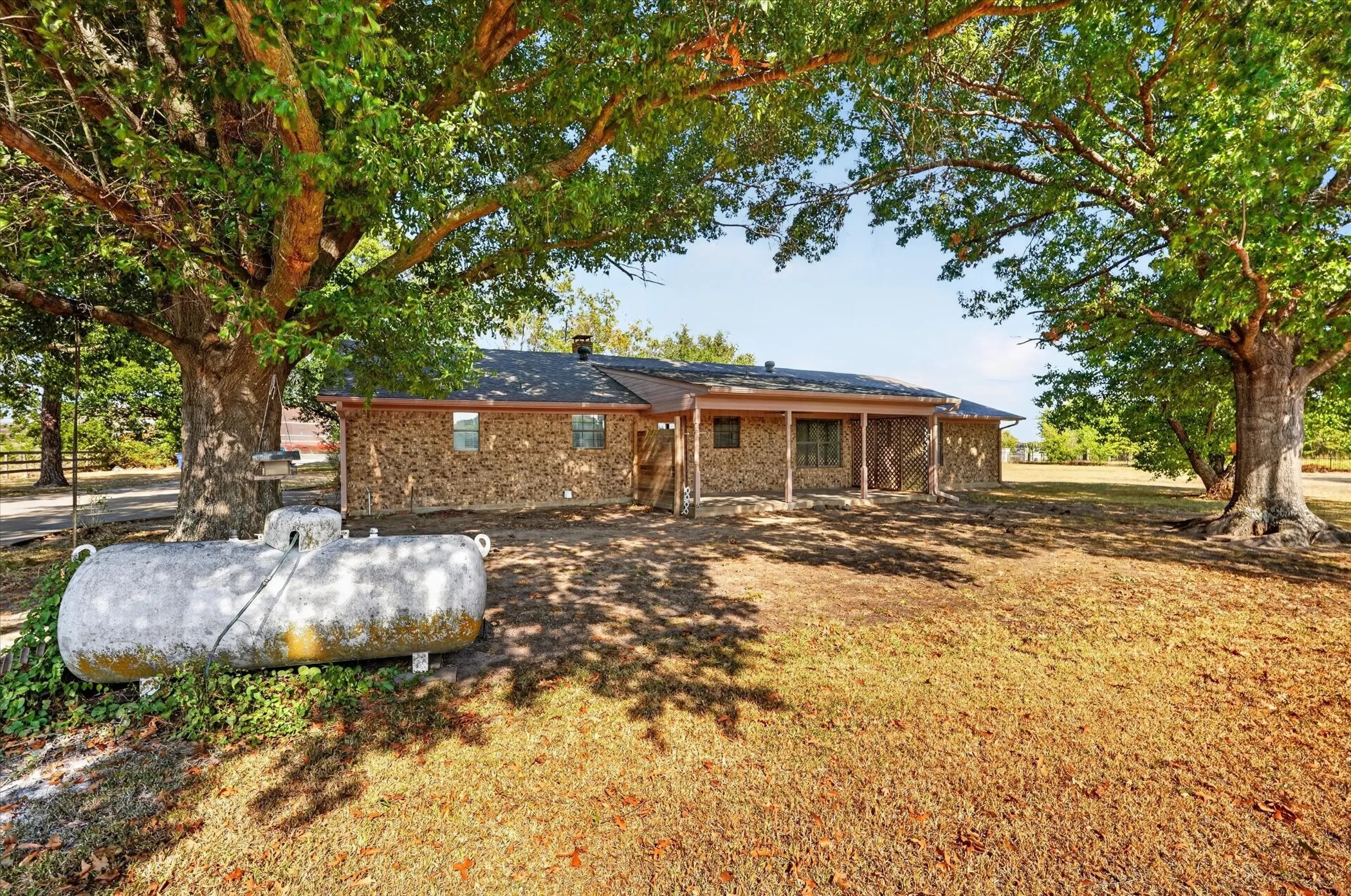 Stone exterior residence with a covered porch and dark roof
