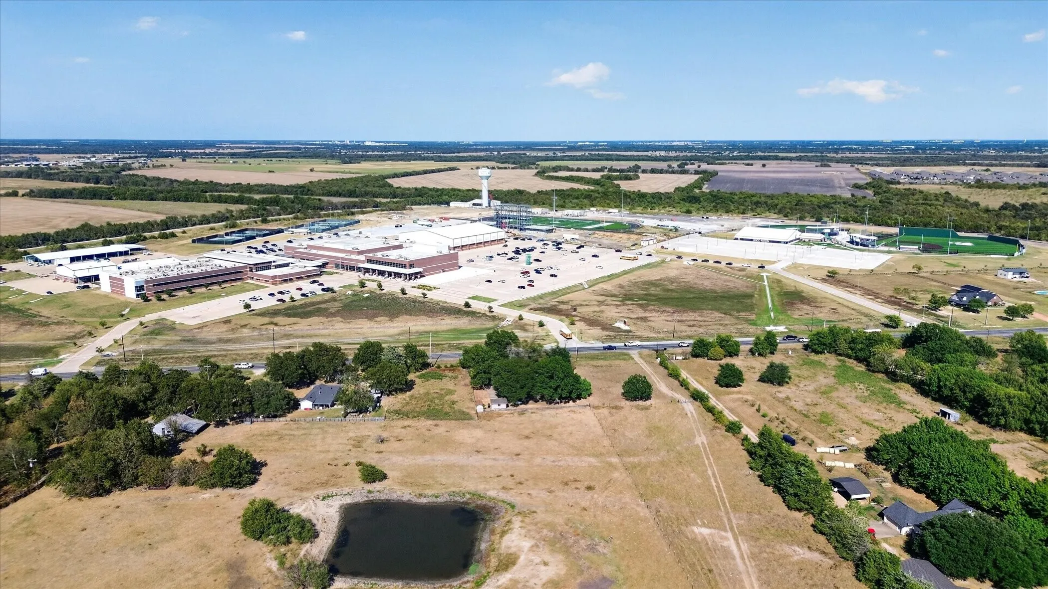 Expansive undeveloped land featuring a natural pond and surrounding wooded areas