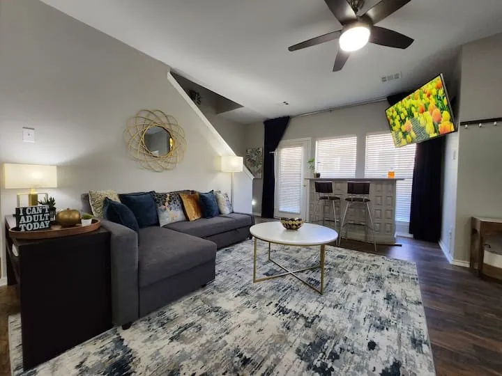 Open living space featuring wood-finish flooring, a built-in bar, and a ceiling fan