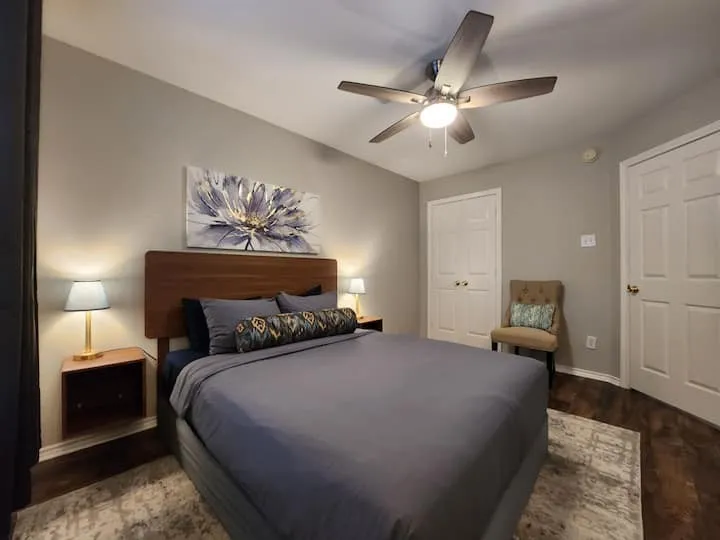 Hardwood-finish flooring, a ceiling fan with integrated lighting, and two panel doors