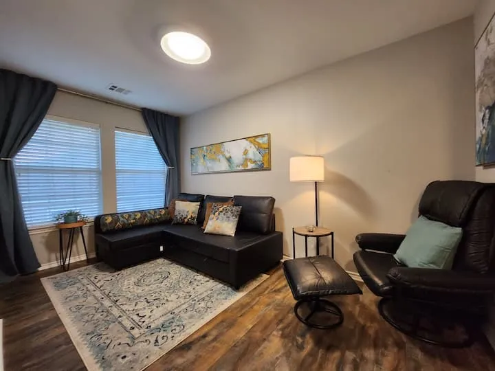 Wood-finish flooring, recessed ceiling light, two windows with blinds, and neutral wall paint