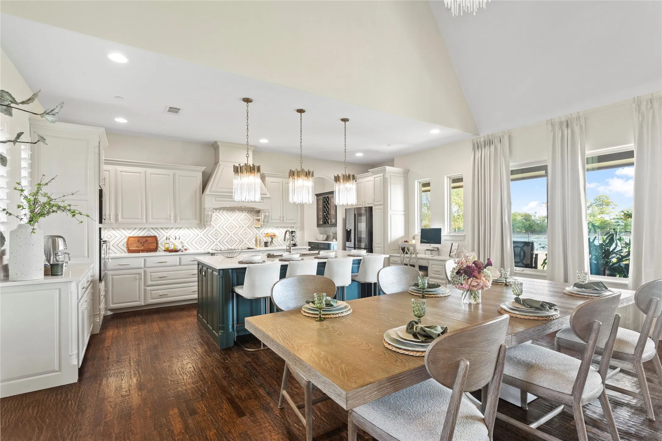 Spacious open-concept kitchen and dining area featuring a vaulted ceiling and dark wood-finish flooring